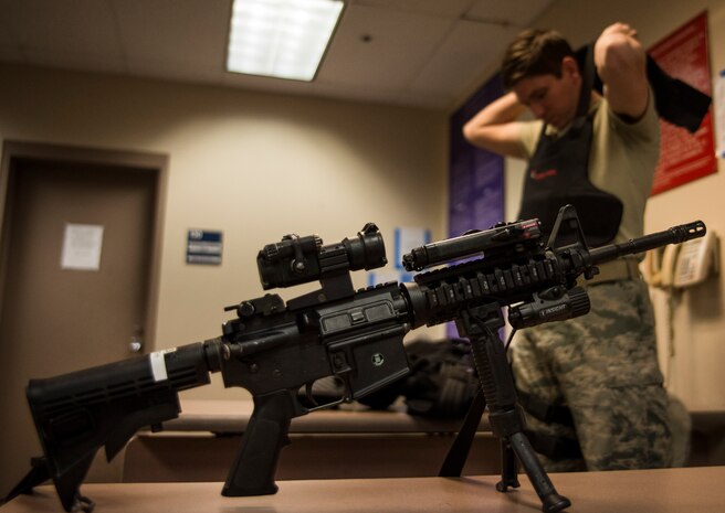 Staff Sgt. Kevin Smith, 628th Security Forces Squadron patrolman, dons a bullet proof vest before beginning an eight to 10 hour patrol Dec. 22, 2013, at Joint Base Charleston – Air Base, S.C. Smith carries an M-4 carbine rifle, 9mm pistol, pepper spray and a Taser to protect the base from attack and to detain uncooperative suspects. (U.S. Air Force photo/ Senior Airman Dennis Sloan)