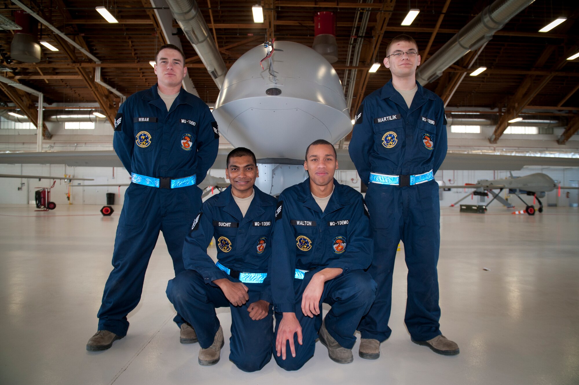 The MQ-1 Predator build team poses next to an MQ-1 after a build-team demonstration at Holloman Air Force Base, N.M., Jan. 17. The MQ-1 build team demonstrates the airmen’s ability to build and prepare an MQ-1 after delivery. The build team travels to different locations to showcase the expedient process of assembly, which on average takes just over half an hour to complete. (U.S. Air Force photo by Airman 1st Class Aaron Montoya / Released)