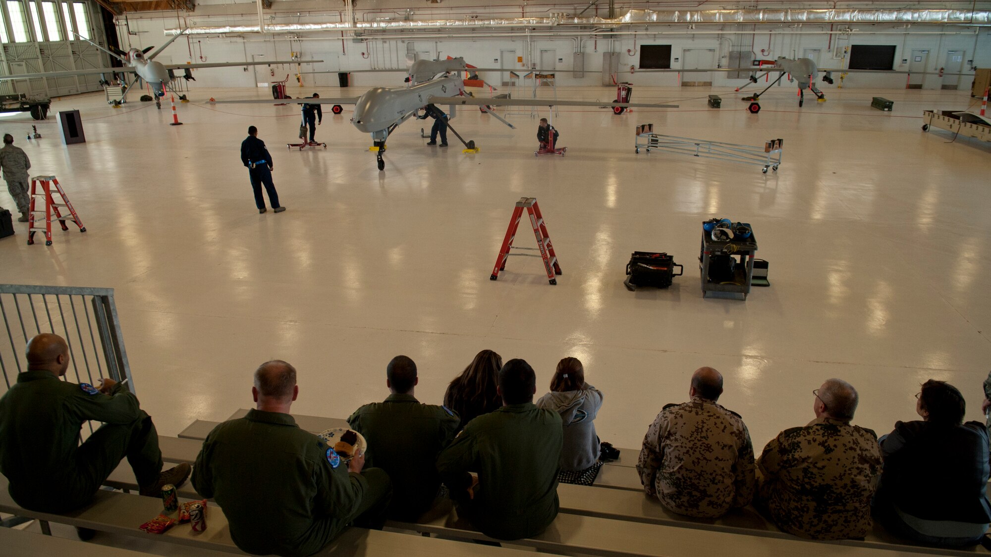 The MQ-1 Predator build team secures the wings during a build-team demonstration at Holloman Air Force Base, N.M., Jan. 17. The MQ-1 build team demonstrates the airmen’s ability to build and prepare an MQ-1 after delivery. The build team travels to different locations to showcase the expedient process of assembly, which on average takes just over half an hour to complete. (U.S. Air Force photo by Airman 1st Class Aaron Montoya / Released)