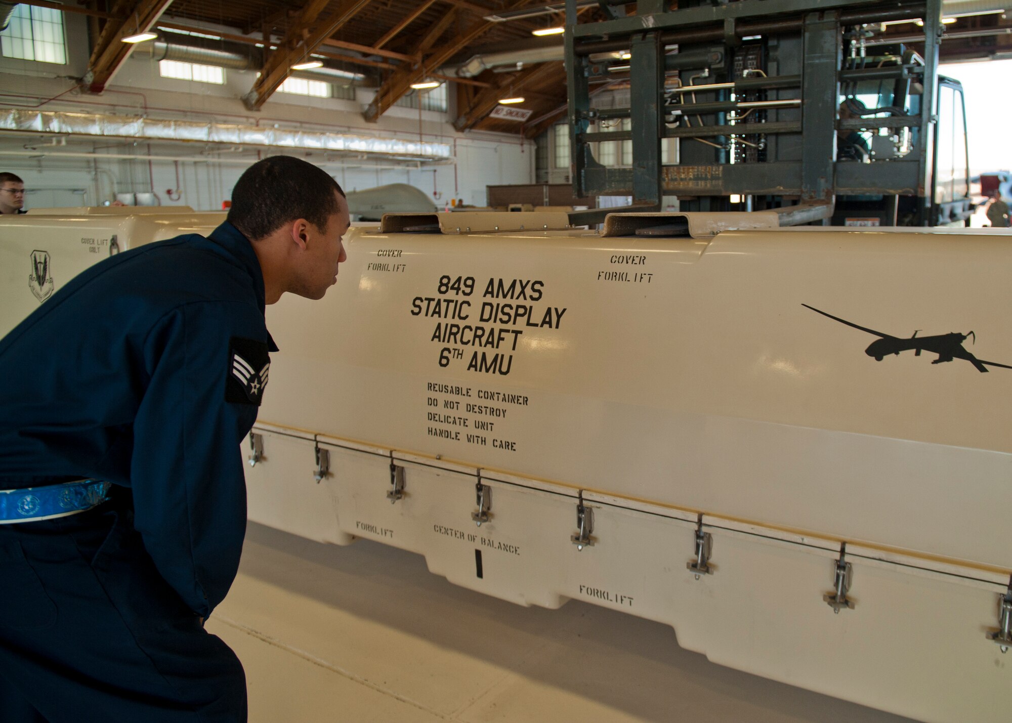 Senior Airman Christopher Walton, 849th Aircraft Maintenance Squadron MQ-1 Predator avionics, guides a forklift while the MQ-1 Predator build team showcases their skills at Holloman Air Force Base, N.M., Jan. 17. The MQ-1 build team demonstrates the airmen’s ability to build and prepare an MQ-1 after delivery. The build team travels to different locations to showcase the expedient process of assembly, which on average takes just over half an hour to complete. (U.S. Air Force photo by Airman 1st Class Aaron Montoya / Released)