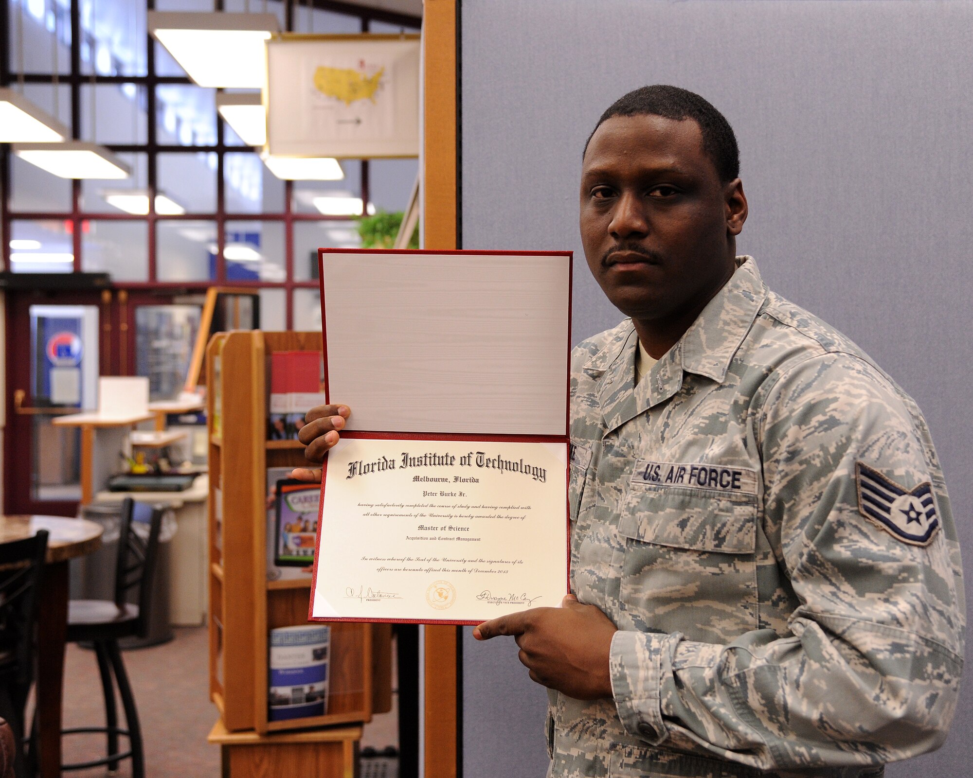 Staff Sgt. Peter Burke, 319th Contracting Flight contract specialist, holds his Florida Institute of Technology master’s degree certificate Jan. 21, 2013, in the Education Center on Grand Forks Air Force Base, N.D. Burke earned both degrees between May of 2009 and December 2013. He earned the two degrees in a total of 16 months during that time frame. (U.S. Air Force photo/ Airman 1st Class Zachiah Roberson)