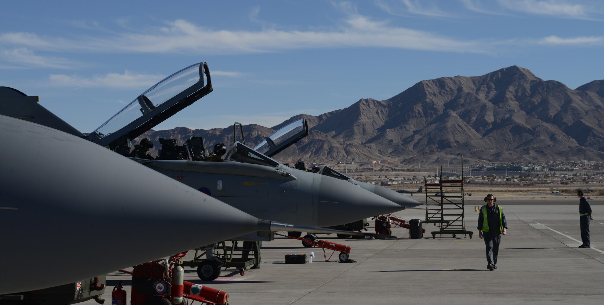 A British Royal Air Force maintainer surveys parked Tornado GR4s on the runway after their arrival at Nellis Air Force Base, Nev., Jan. 22, 2013. The IX (B) Squadron whose motto is, "Per noctum volamus - Throughout the night we fly," traces their heritage from World War I to Operation Iraqi Freedom. (U.S. Air Force photo by Senior Airman Benjamin Sutton/Released)