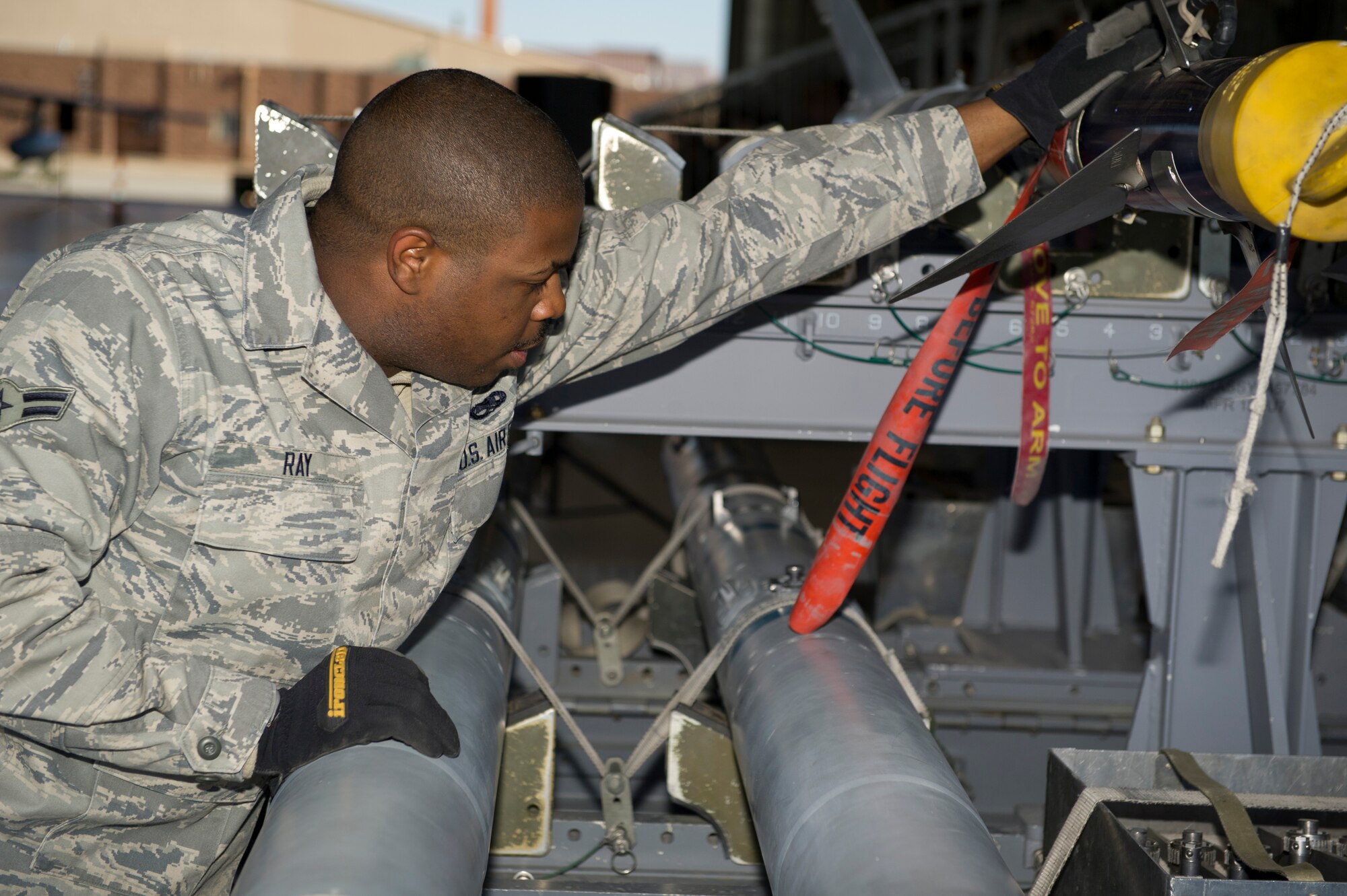 Airman 1st Class Orlandus Ray, 49th Aircraft Maintenance Squadron weapons-load- crew member, prepares inert missiles for a quarterly load crew competition at Holloman Air Force Base, N.M., Jan. 17. This was the last load crew competition that the F-22 Raptor will participate in at Holloman. The F-22 Raptor load crew competed to have their skills evaluated alongside the MQ-9 Reaper and the German Air Force Tornado Load crews. For the competition, points were awarded for weapons loading, tool kit inspection and uniform inspection. (U.S. Air Force photo by Airman 1st Class Chase Cannon/Released)