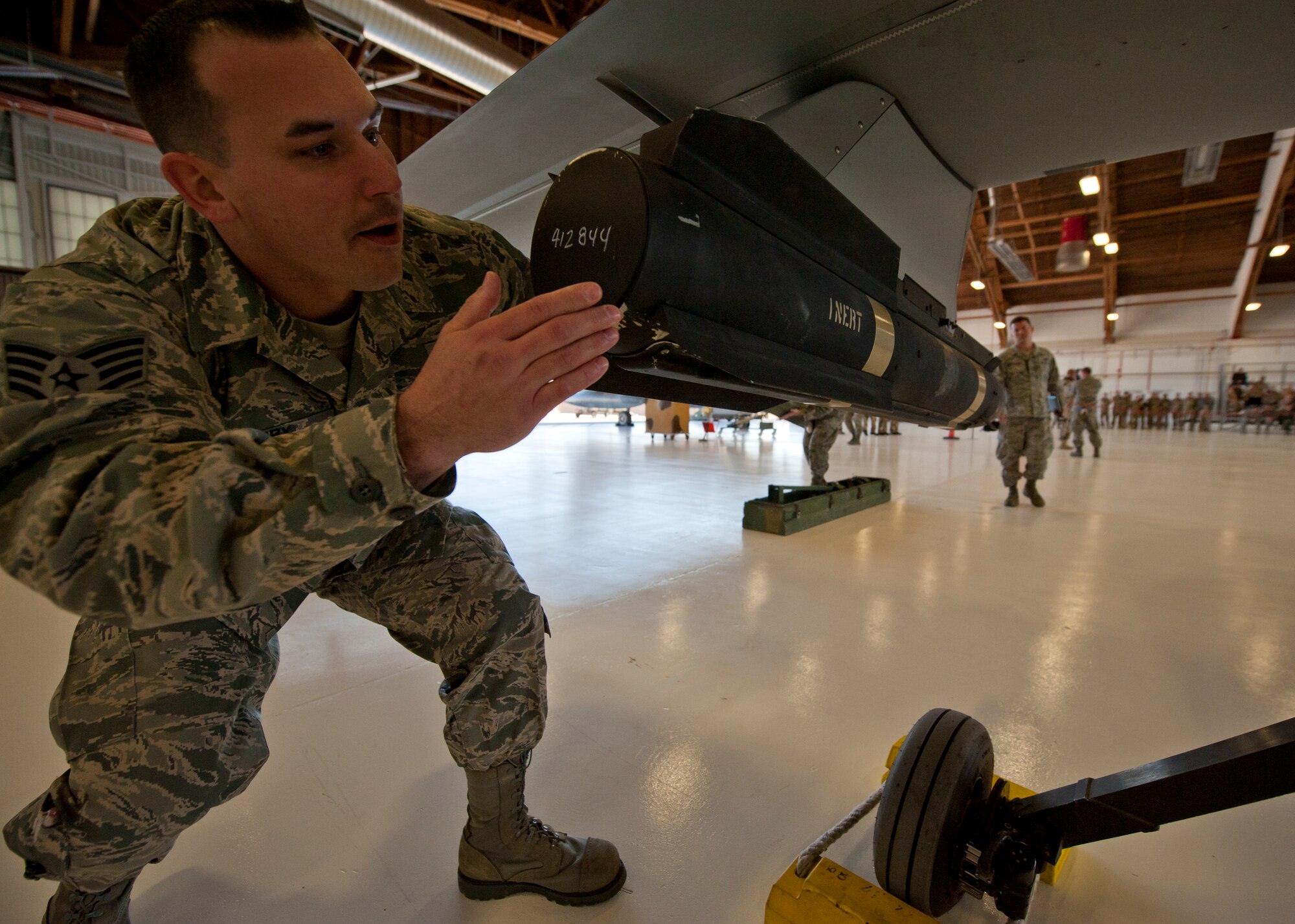 Staff Sgt. Kenneth Duby from the 849th Aircraft Maintenance Squadron, loads an inert missile onto an MQ-1 Predator during a quarterly load-crew competition at Holloman Air Force Base, N.M., Jan. 17. The 849th AMXS pitted two MQ-1 Predator load crews against each other to evaluate who could prepare the aircraft for combat the quickest and with the fewest procedural errors. (U.S. Air Force photo by Airman 1st Class Aaron Montoya / Released)