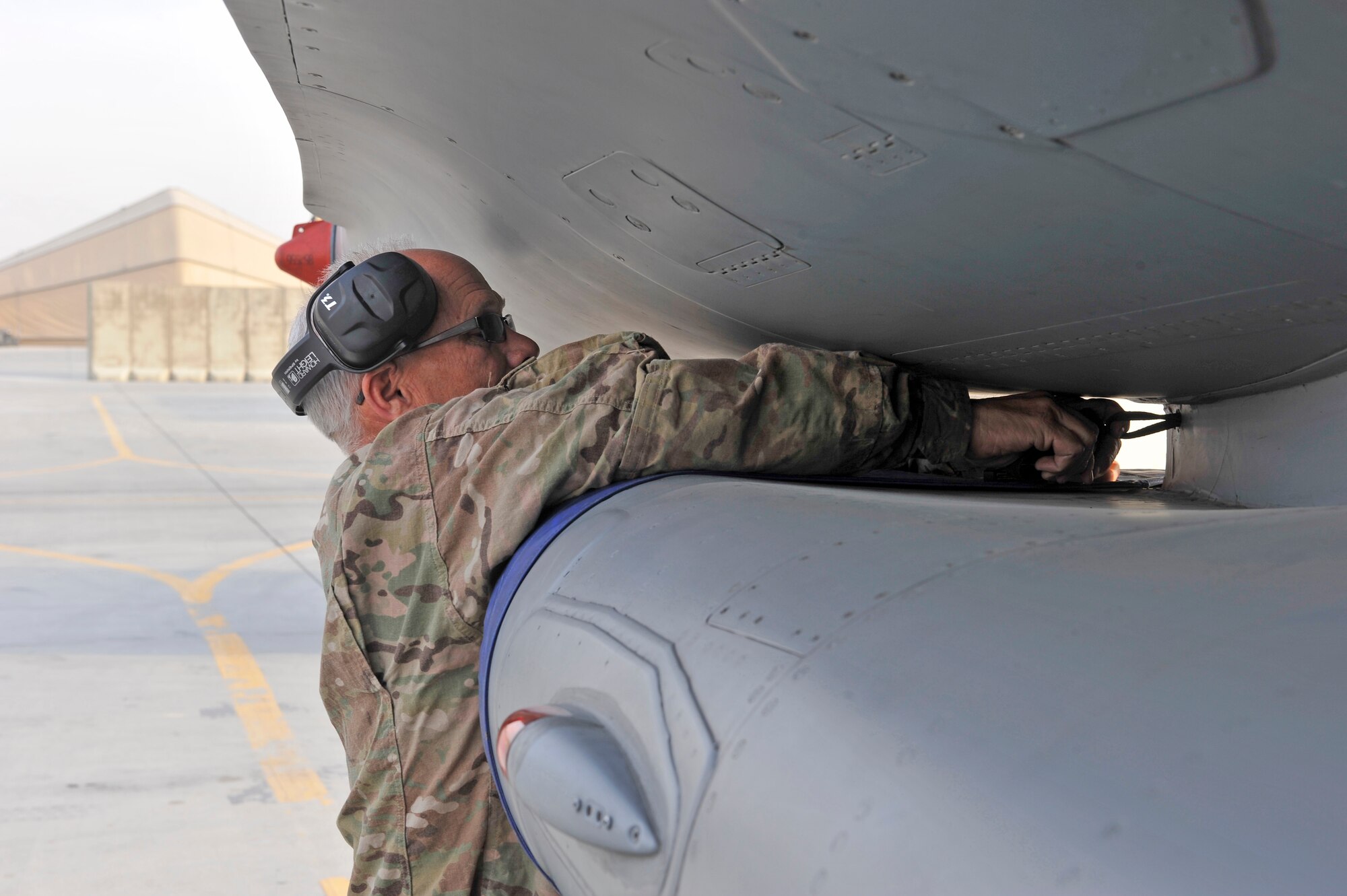 U.S. Air Force Master Sgt. Doyle Easterling reattaches the engine intake cover after an F-16 engine test run at Bagram Airfield, Afghanistan, Jan. 20, 2014. Easterling is deployed out of Carswell Joint Reserve Base in Fort Worth, Texas to Bagram, and will be retiring this year after 36 years of military service. (U.S. Air Force photo by Senior Master Sgt. Gary J. Rihn/Released)