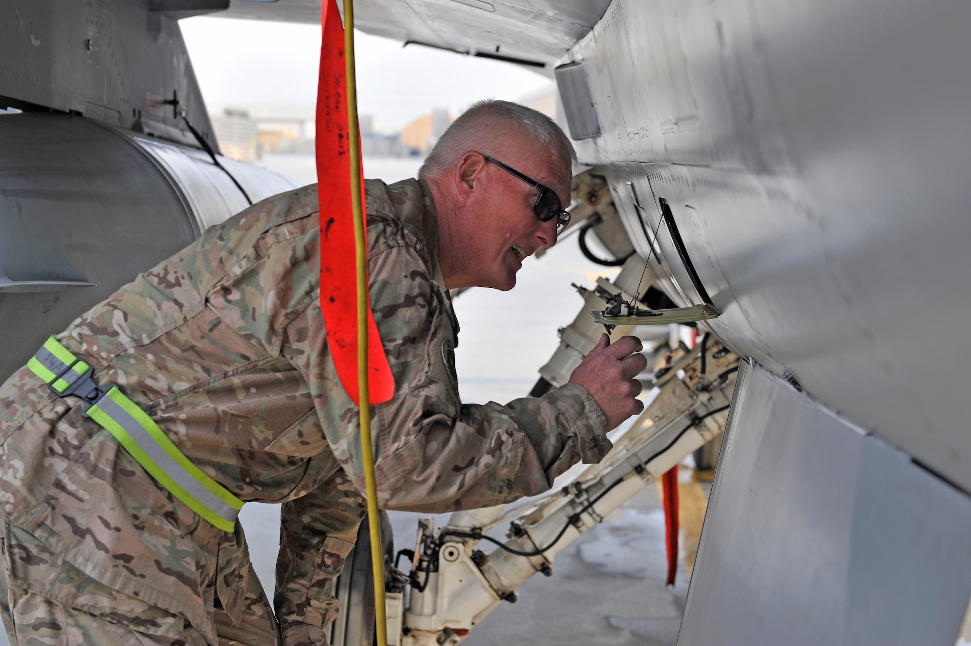 U.S. Air Force Senior Master Sgt. Paul Jordan checks inside a panel while performing an inspection on an F-16 at Bagram Airfield, Afghanistan, Jan. 20, 2014. Jordan is deployed out of Carswell Joint Reserve Base in Fort Worth, Texas to Bagram, and will be retiring this year after 42 years of military service. (U.S. Air Force photo by Senior Master Sgt. Gary J. Rihn/Released)