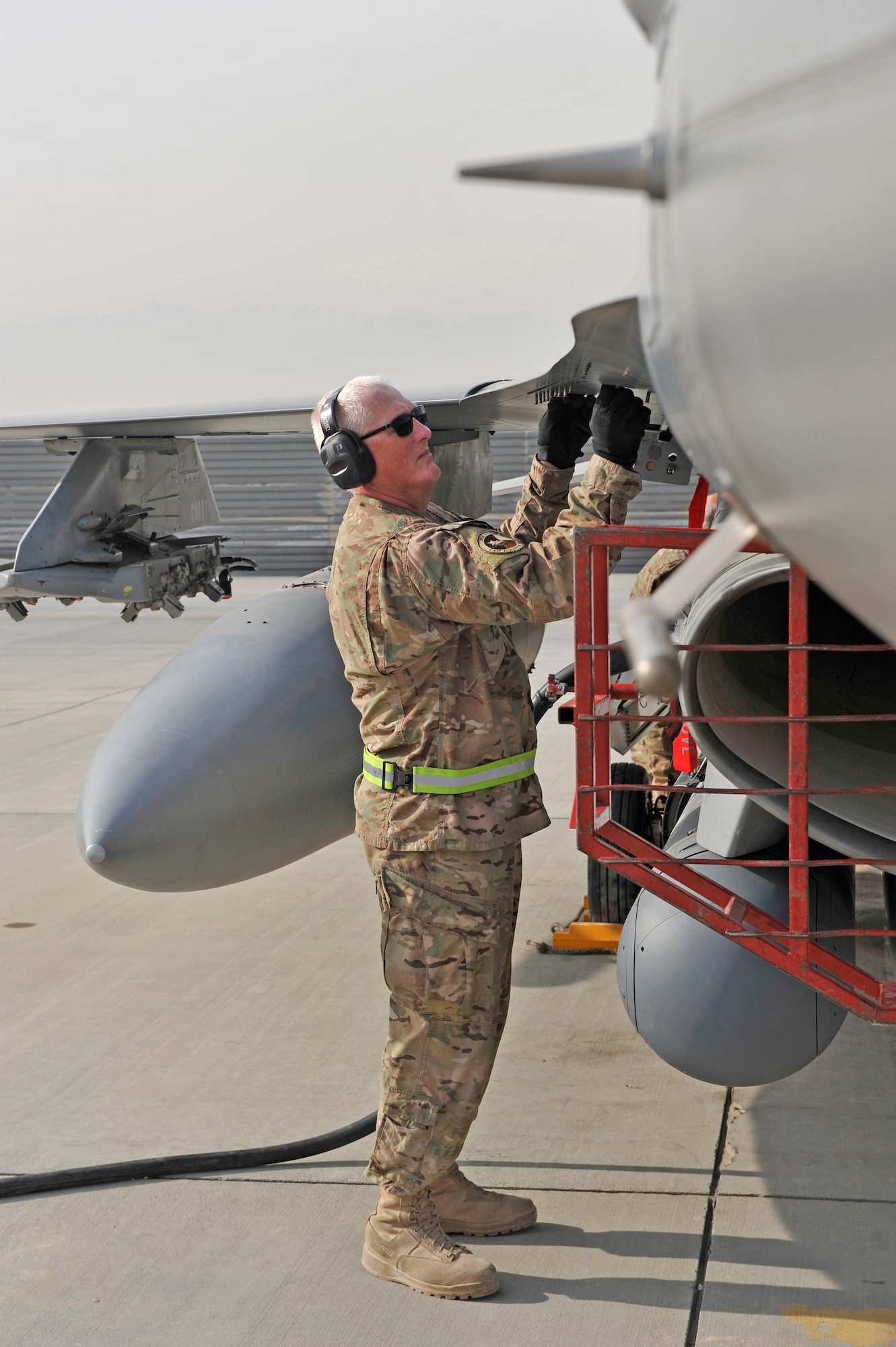 U.S. Air Force Senior Master Sgt. Paul Jordan reattaches a panel after performing an inspection on an F-16 at Bagram Airfield, Afghanistan, Jan. 20, 2014. Jordan is deployed out of Carswell Joint Reserve Base in Fort Worth, Texas to Bagram, and will be retiring this year after 42 years of military service. (U.S. Air Force photo by Senior Master Sgt. Gary J. Rihn/Released)