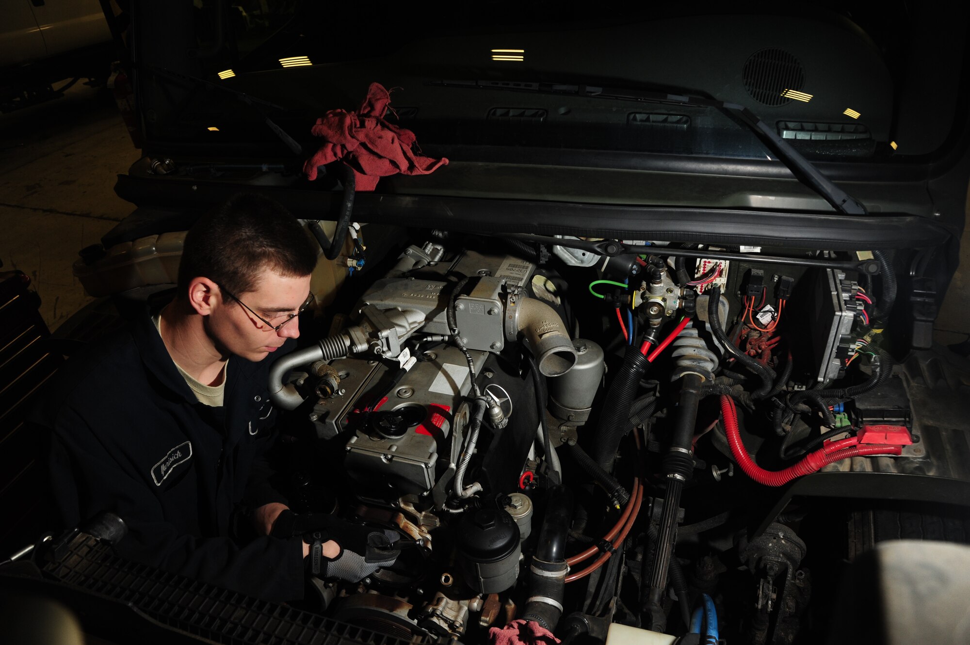Senior Airman Justin Yurisich, a 19th Logistics Readiness Squadron vehicle management journeyman, removes bolts from the oil cooler Jan. 22, 2014, at Little Rock Air Force Base, Ark. Yurisich removes the oil cooler to replace the seal because it was leaking causing the engine to overheat. (U.S. Air Force photo by Senior Airman Kaylee Clark)