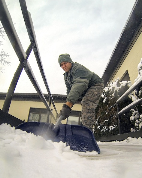 HANSCOM AIR FORCE BASE, Mass. – Master Sgt. Mark Caldwell, 319th Recruiting Squadron, shovels snow outside of Building 1508 after a missed snowstorm dropped a small amount of snow Jan. 22. During snow and ice events, facility managers should ensure interior floors are free of slip hazards, assist civil engineering snow removal by coordinating the movement of vehicles to improve access for snow removal in parking lots and call CE customer service at 781-225-2990 to report any problems or coordinate special requirements. (U.S. Air Force photo by Mark Herlihy)