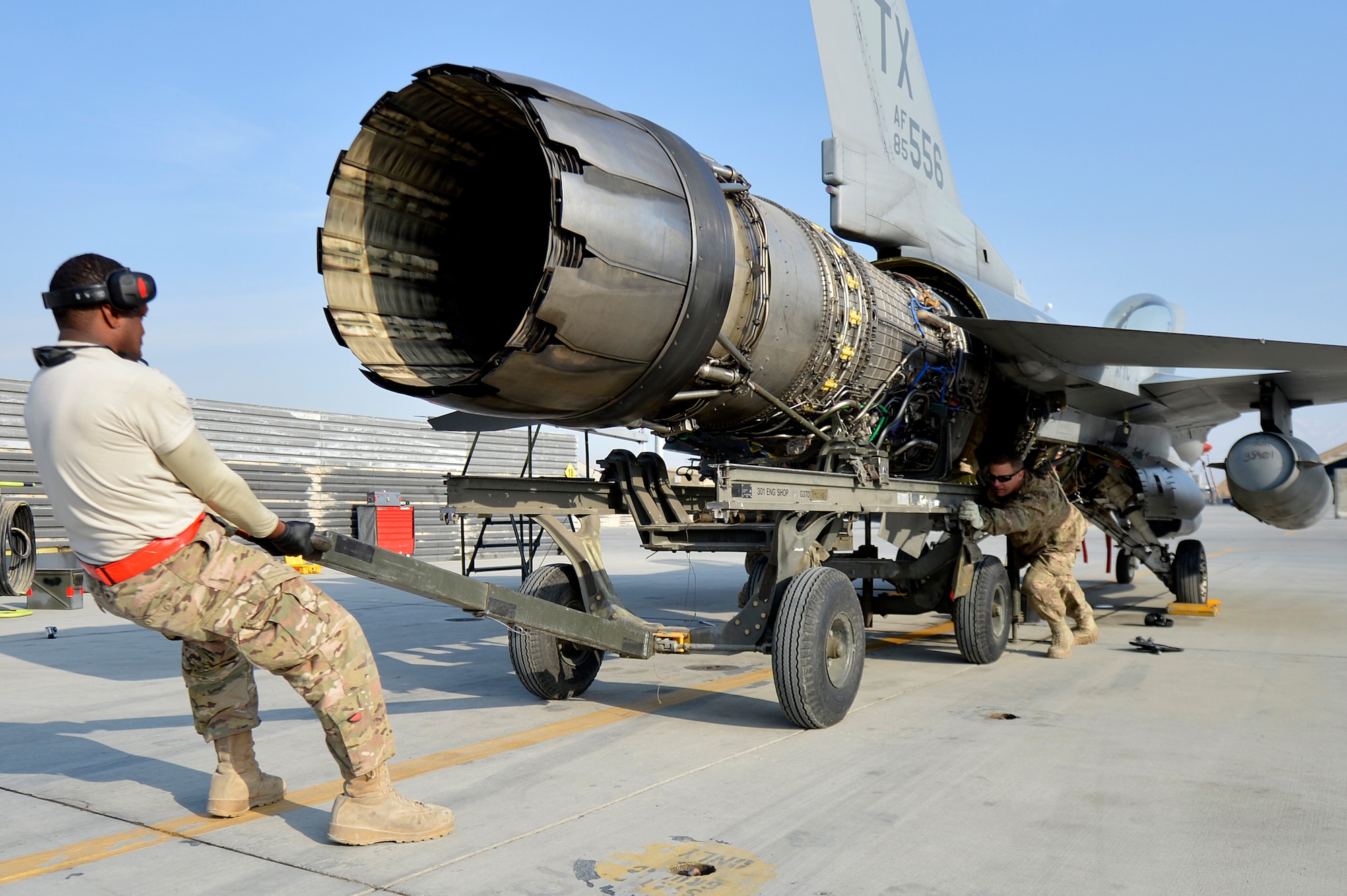 U.S. Air Force Airmen assigned to the 455th Expeditionary Aircraft Maintenance Squadron work to remove the engine from an F-16 Fighting Falcon at Bagram Airfield, Afghanistan, Jan. 22, 2014. The engine was scheduled for removal due to a bad hydraulic line. (U.S. Air Force photo by Senior Airman Kayla Newman/Released)