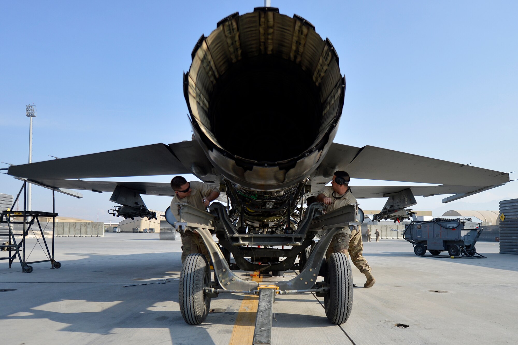 U.S. Air Force Airmen assigned to the 455th Expeditionary Aircraft Maintenance Squadron work to remove the engine from an F-16 Fighting Falcon at Bagram Airfield, Afghanistan, Jan. 22, 2014. The engine was scheduled for removal due to a bad hydraulic line. (U.S. Air Force photo by Senior Airman Kayla Newman/Released)