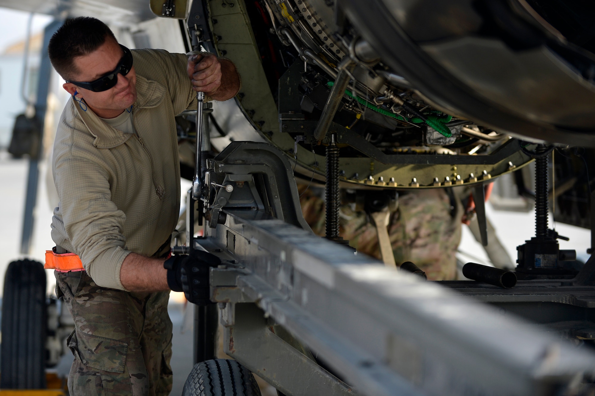 A U.S. Air Force Airman assigned to the 455th Expeditionary Aircraft Maintenance Squadron removes the engine from an F-16 Fighting Falcon at Bagram Airfield, Afghanistan, Jan. 22, 2014. Airmen worked to remove the engine of the aircraft due to a bad hydraulic line. (U.S. Air Force photo by Senior Airman Kayla Newman/Released)