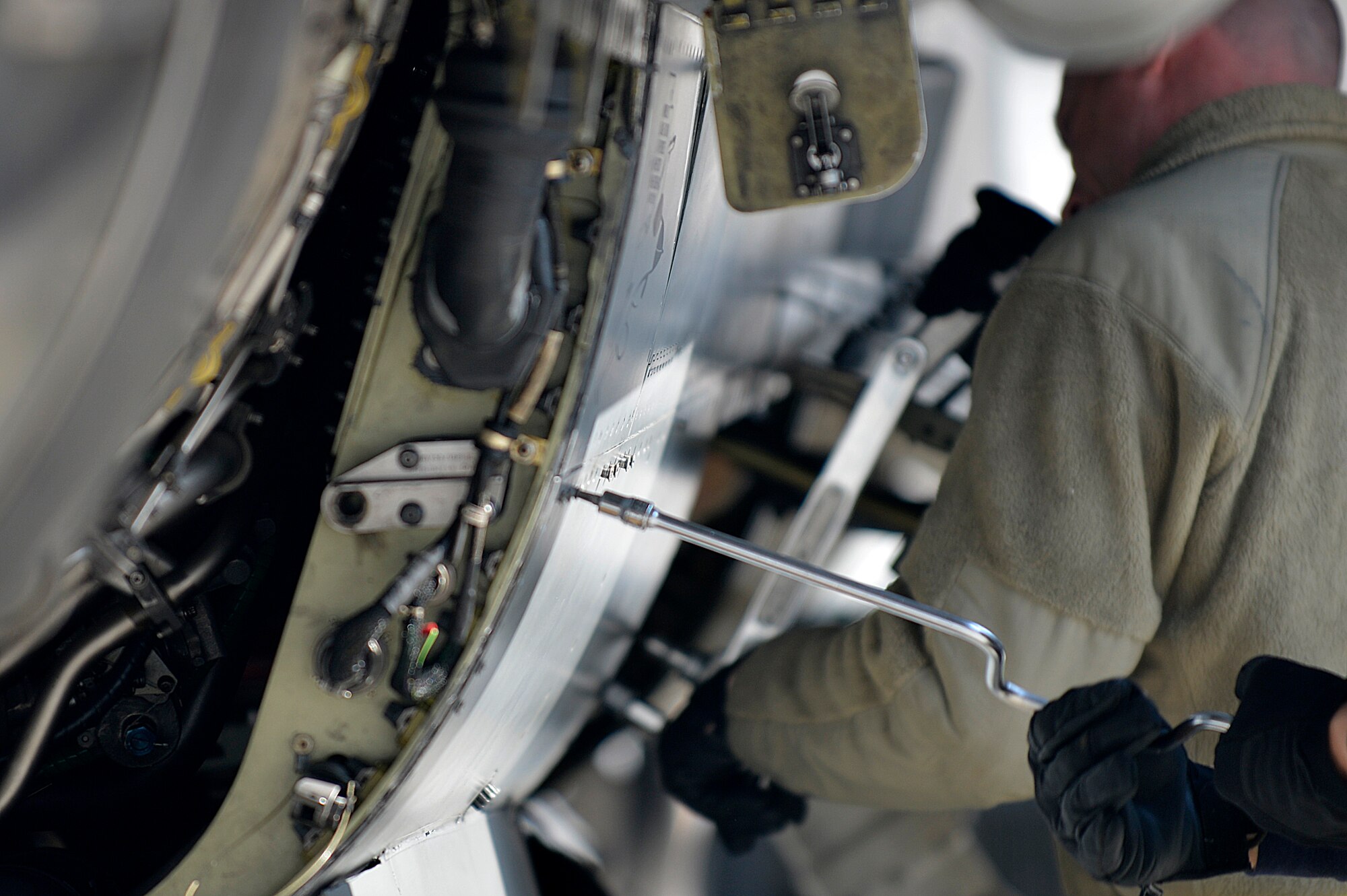 A U.S. Air Force Airman assigned to the 455th Expeditionary Aircraft Maintenance Squadron works in the panel of an engine on an F-16 Fighting Falcon at Bagram Airfield, Afghanistan, Jan. 22, 2014. Airmen worked to remove the engine due to a bad hydraulic line. (U.S. Air Force photo by Senior Airman Kayla Newman/Released)