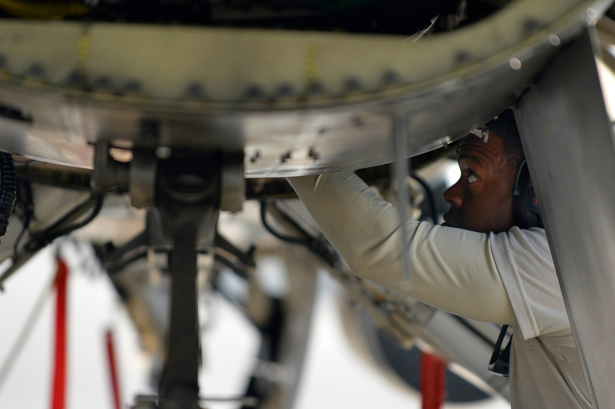 A U.S. Air Force Airman assigned to the 455th Expeditionary Aircraft Maintenance Squadron works in the panel of an engine on an F-16 Fighting Falcon at Bagram Airfield, Afghanistan, Jan. 22, 2014. Airmen worked to remove the engine due to a bad hydraulic line. (U.S. Air Force photo by Senior Airman Kayla Newman/Released)