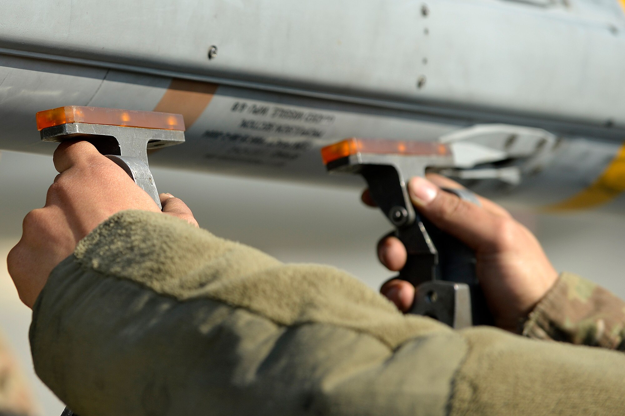 A U.S. Air Force Airman assigned to the 455th Expeditionary Aircraft Maintenance Squadron prepares to secure a missile from an F-16 Fighting Falcon at Bagram Airfield, Afghanistan, Jan. 22, 2014. The missiles were removed from the aircraft to prepare for major maintenance on the engine. (U.S. Air Force photo by Senior Airman Kayla Newman/Released)