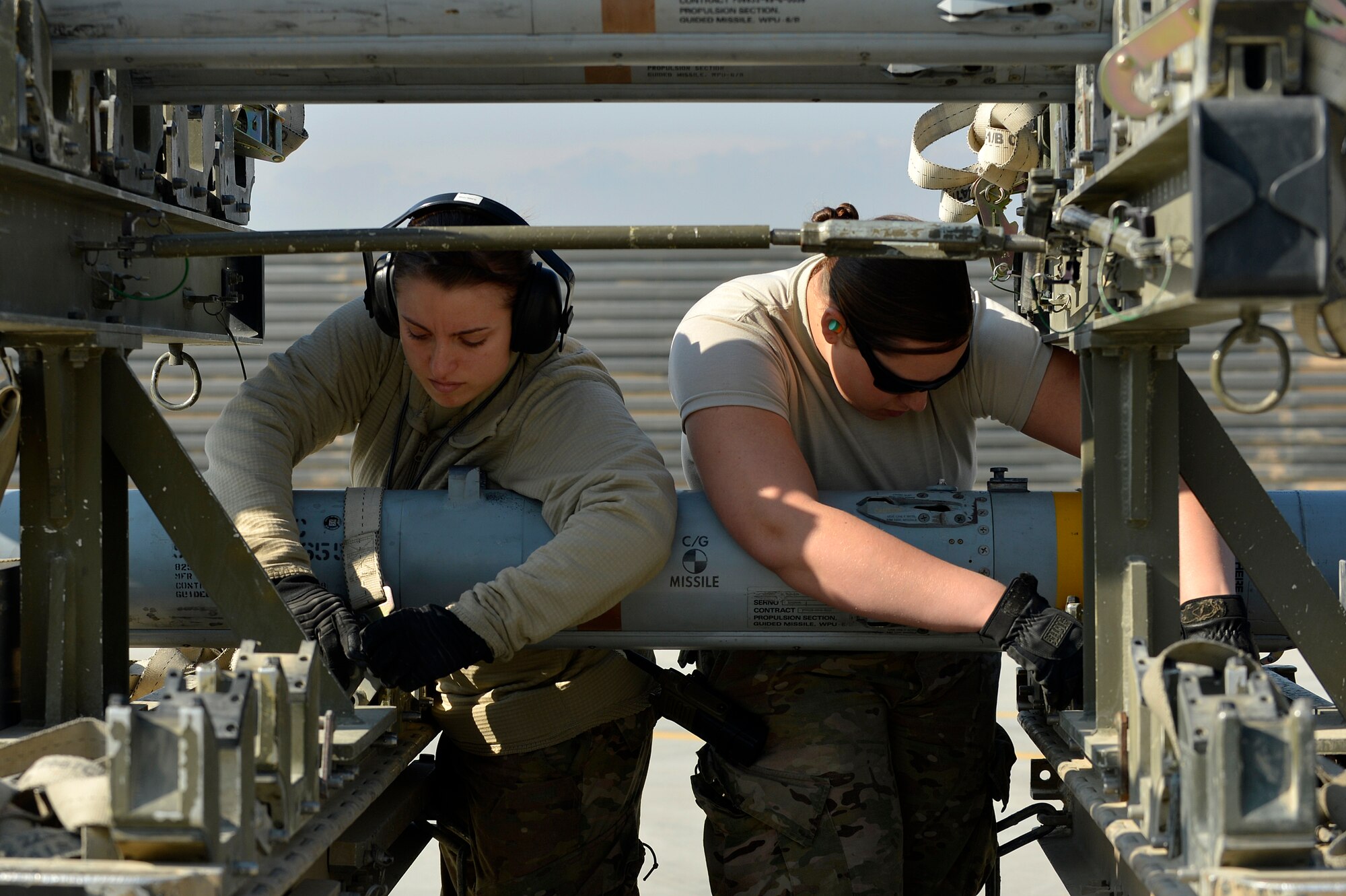Two U.S. Air Force Airmen assigned to the 455th Expeditionary Aircraft Maintenance Squadron secure missiles from an F-16 Fighting Falcon at Bagram Airfield, Afghanistan, Jan. 22, 2014. Before any major maintenance can be performed, the missiles must be removed from the aircraft. (U.S. Air Force photo by Senior Airman Kayla Newman/Released)