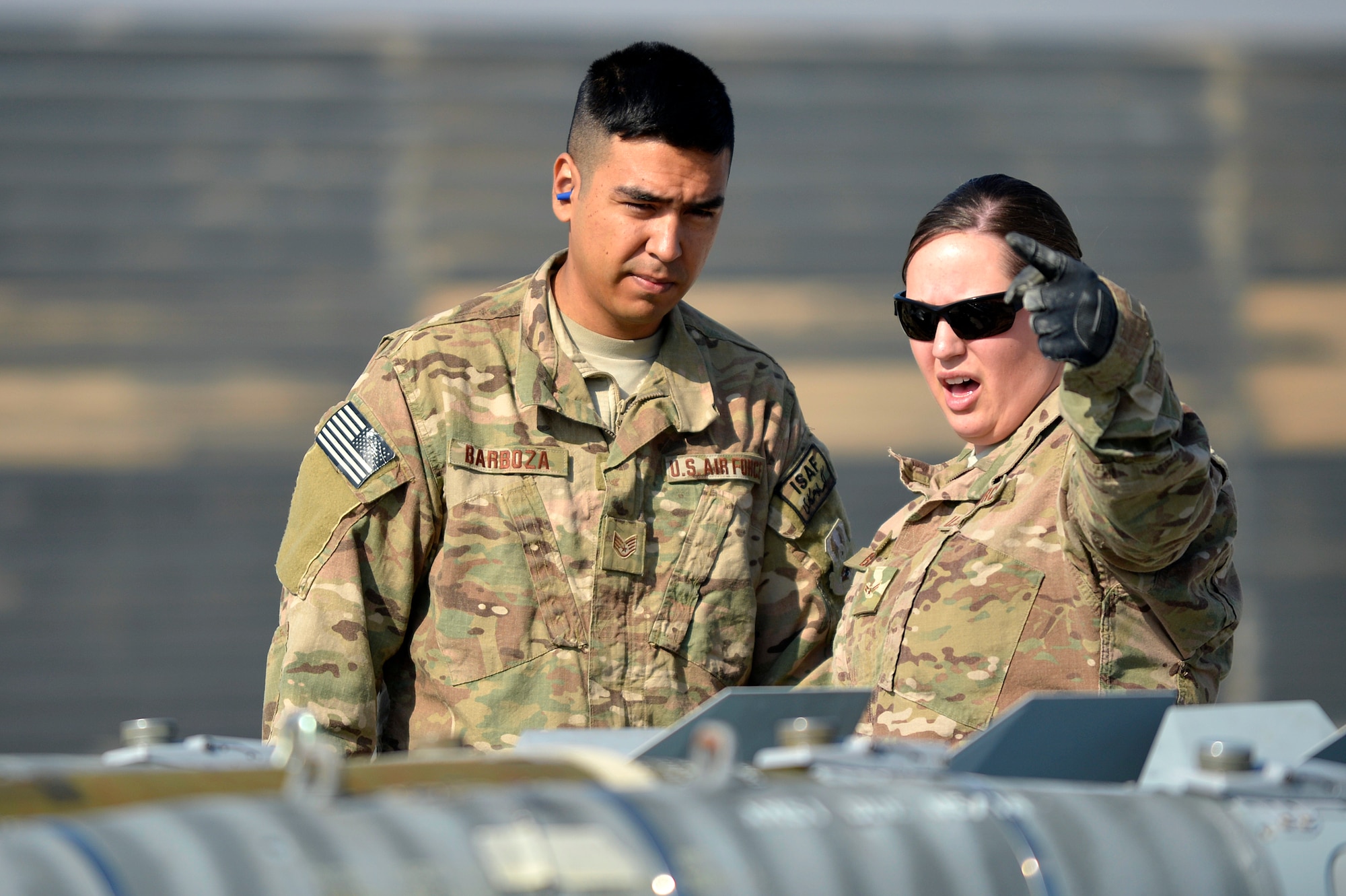 Two U.S. Air Force Airmen assigned to the 455th Expeditionary Aircraft Maintenance Squadron discuss missile loading at Bagram Airfield, Afghanistan, Jan. 22, 2014. The Airmen removed missiles from an F-16 Fighting Falcon in preparation for major maintenance. (U.S. Air Force photo by Senior Airman Kayla Newman/Released)