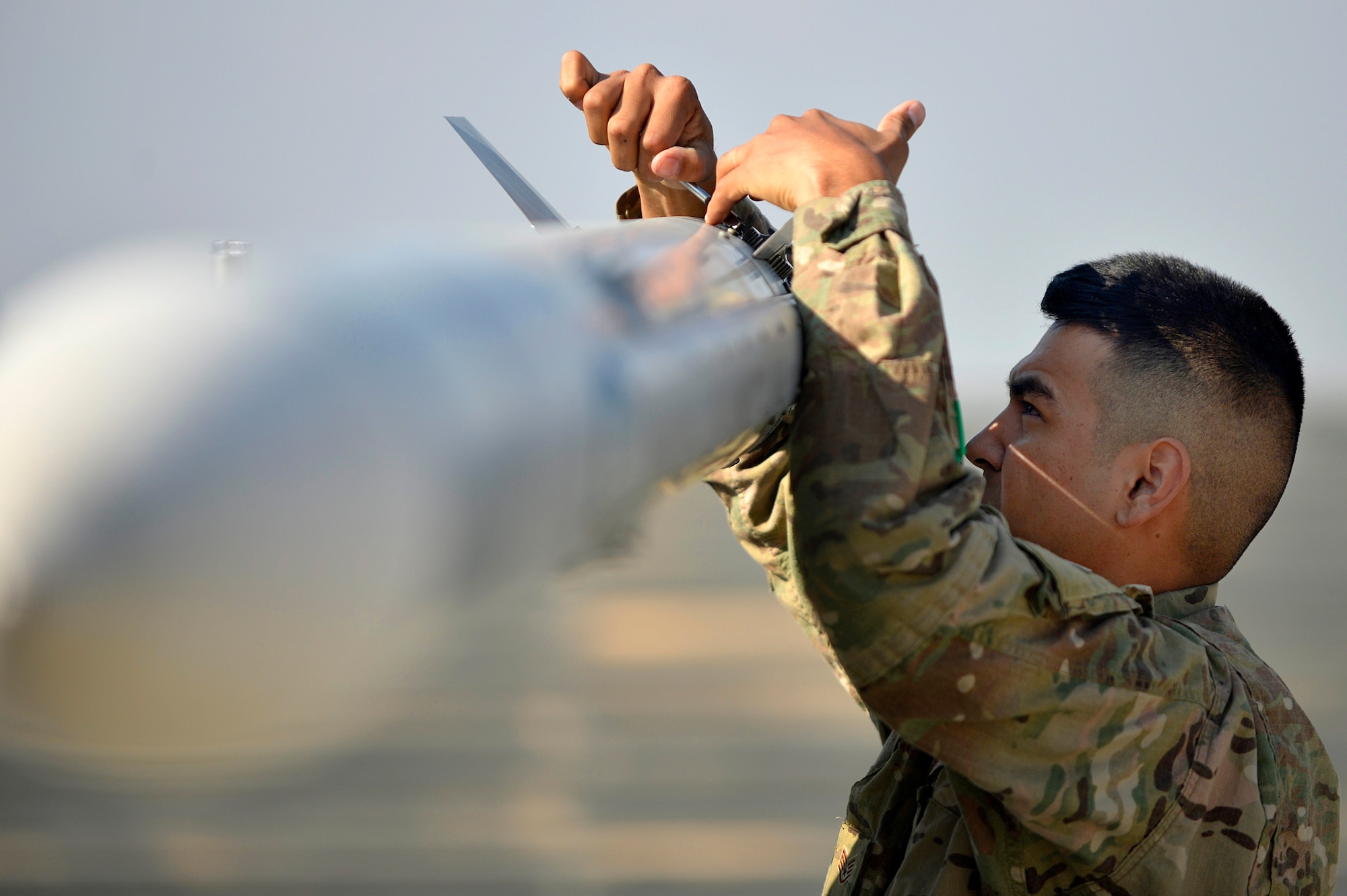 U.S. Air Force Staff Sgt. Robert Barboza, 455th Expeditionary Aircraft Maintenance Squadron, prepares to down-load an F-16 Fighting Falcon at Bagram Airfield, Afghanistan, Jan. 22, 2014. Before any major maintenance can be performed, the missiles must be removed from the aircraft. (U.S. Air Force photo by Senior Airman Kayla Newman/Released)