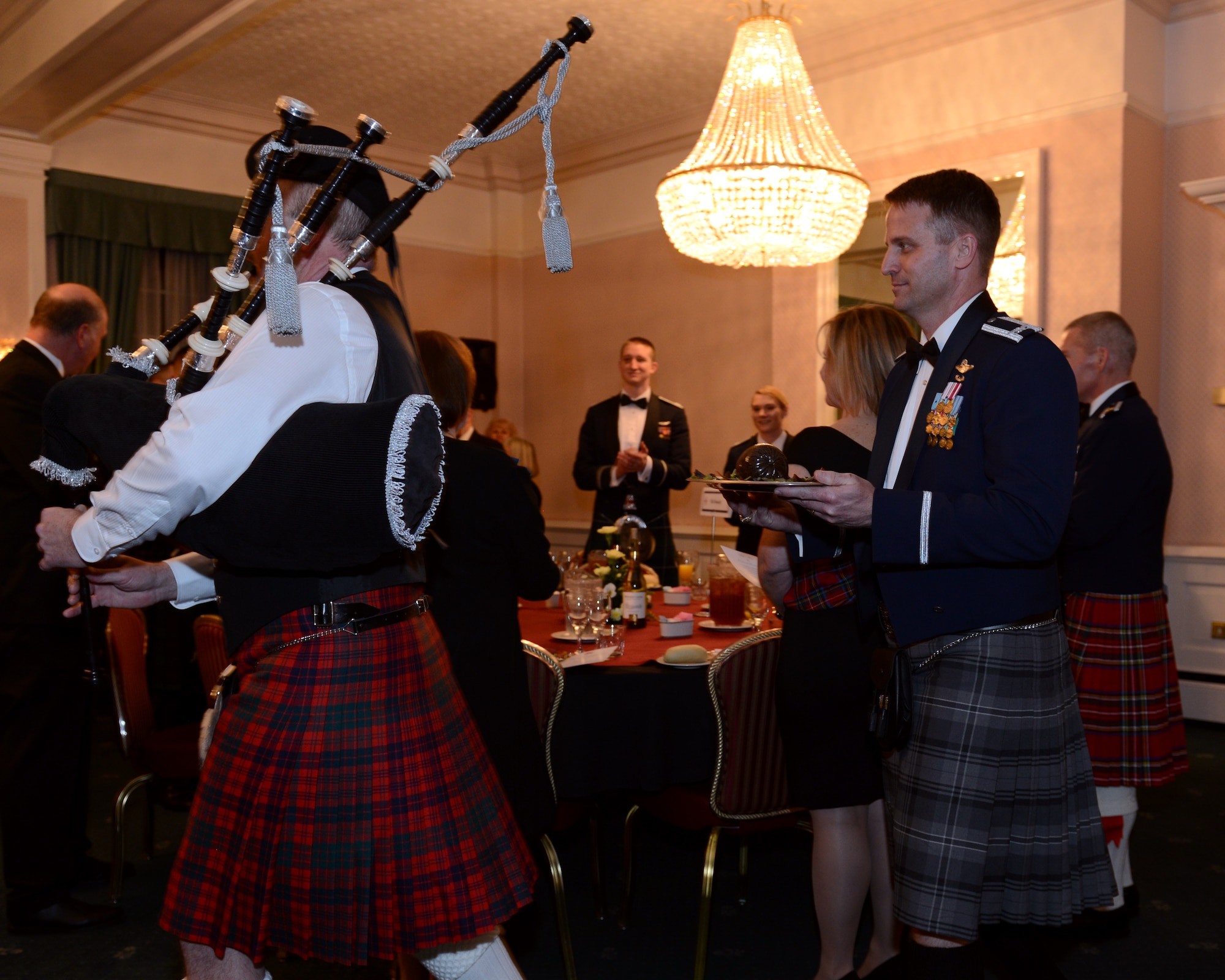 U.S. Air Force Col. David Cox, right, 100th Air Refueling Wing vice commander, carries a platter of haggis during the British-American Committee Burns Night supper Jan. 18, 2014, in Middleton Hall on RAF Mildenhall, England. The committee hosts this and other social events each year, bringing both communities together for a richer cultural experience. (U.S. Air Force photo by Airman 1st Class Preston Webb/Released)