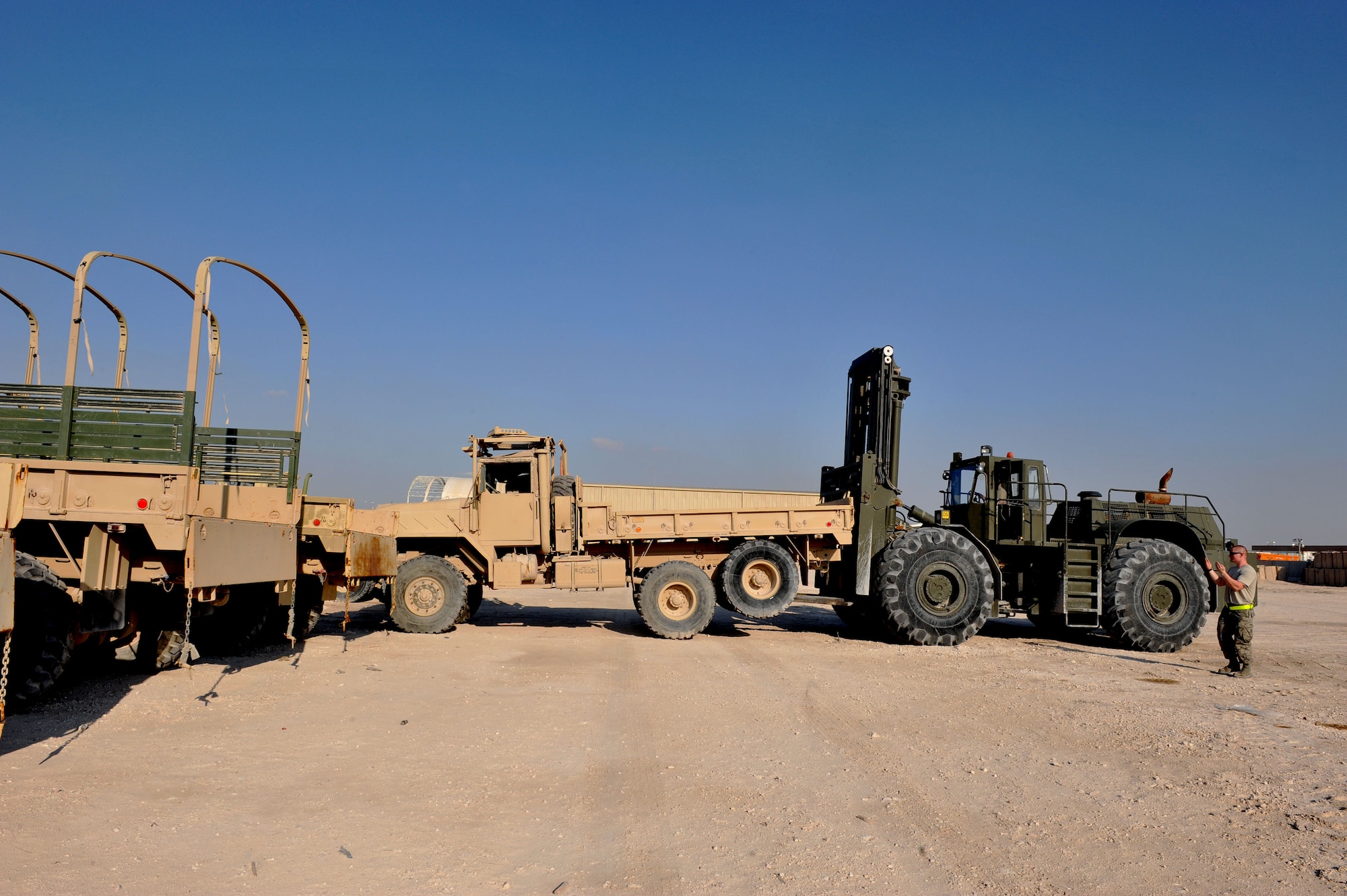Senior Airman Hunter Spears directs Senior Airman Shane Zimmerman as he moves an inoperable  U.S. Army M939 5-Ton vehicle at Al Udeid Air Base, Qatar, Jan. 17, 2014. The 379th Expeditionary Logistics Readiness Squadron was tasked to move 51 vehicles and miscellaneous pieces of equipment from the former 11th Air Defense Artillery Brigade, 1st Battalion, 43rd Air Defense Artillery Regiment site, to a collection point for further distribution. All vehicles were inoperable and had to be towed or loaded onto a flatbed trailer for movement. This was the final push in the complete movement of the 1-43rd ADA from their old site, to their new location. The move took three days to complete. Spears is a 379th ELRS vehicle operator deployed from Minot Air Force Base, N.D., and a Fort Smith, Ark., native.  Zimmerman is a 379th ELRS vehicle operator deployed from Eglin Air Force Base, Fla., and a Bear Creek, N.C., native. (U.S. Air Force photo by Master Sgt. David Miller)
