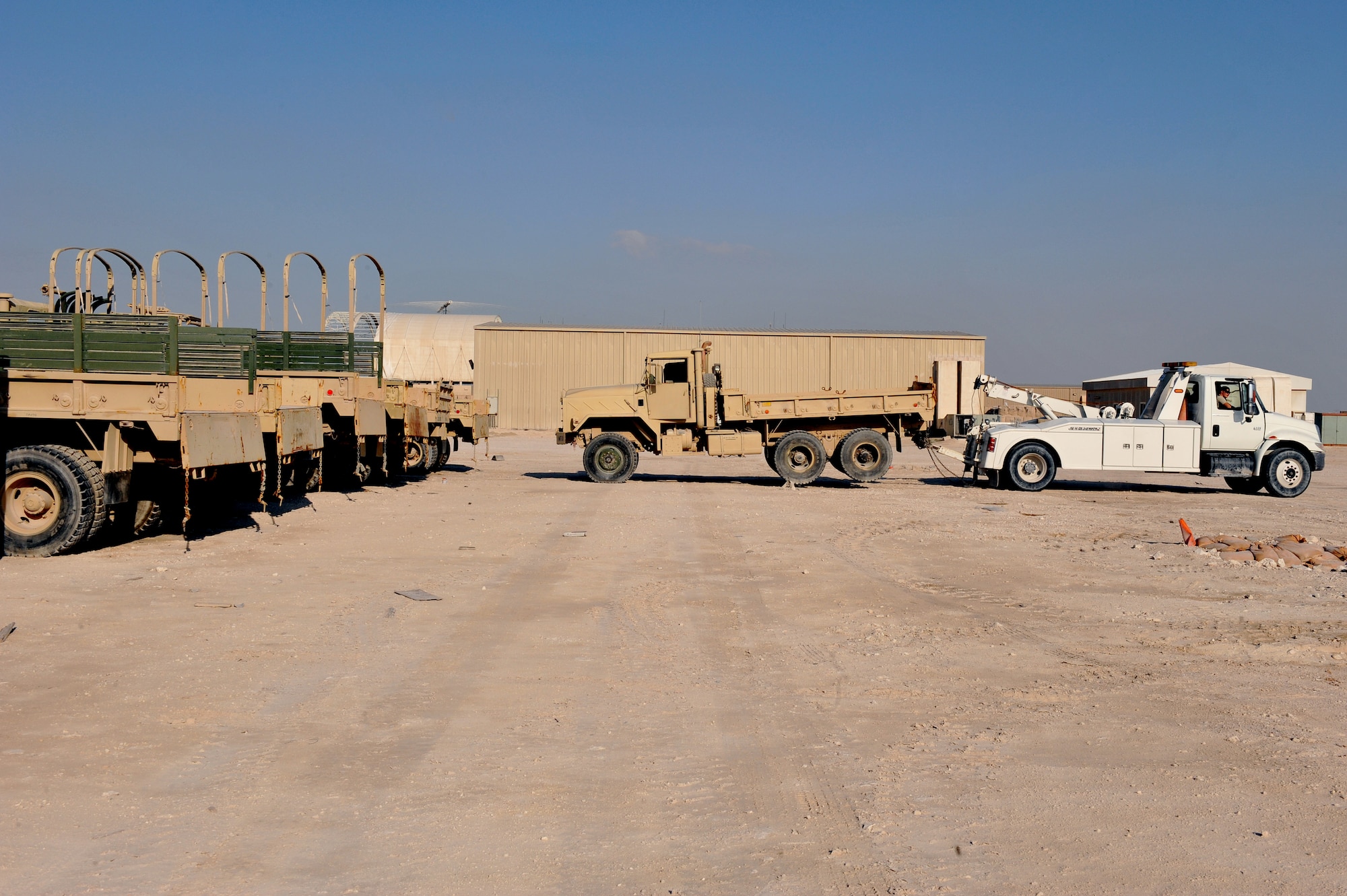 Senior Airman Richard Narvaez tows a U.S. Army M939 5-Ton vehicle to a collection point at Al Udeid Air Base, Qatar, Jan. 17, 2014. The 379th Expeditionary Logistics Readiness Squadron was tasked to move 51 vehicles and miscellaneous pieces of equipment from the former 11th Air Defense Artillery Brigade, 1st Battalion, 43rd Air Defense Artillery Regiment site, to a collection point for further distribution. All vehicles were inoperable and had to be towed or loaded onto a flatbed trailer for movement. This was the final push in the complete movement of the 1-43rd ADA from their old site, to their new location. The move took three days to complete. Narvaez is a 379th ELRS vehicle operator deployed from Minot Air Force Base,N.D., and a Bronx, N.Y., native.  (U.S. Air Force photo by Master Sgt. David Miller)