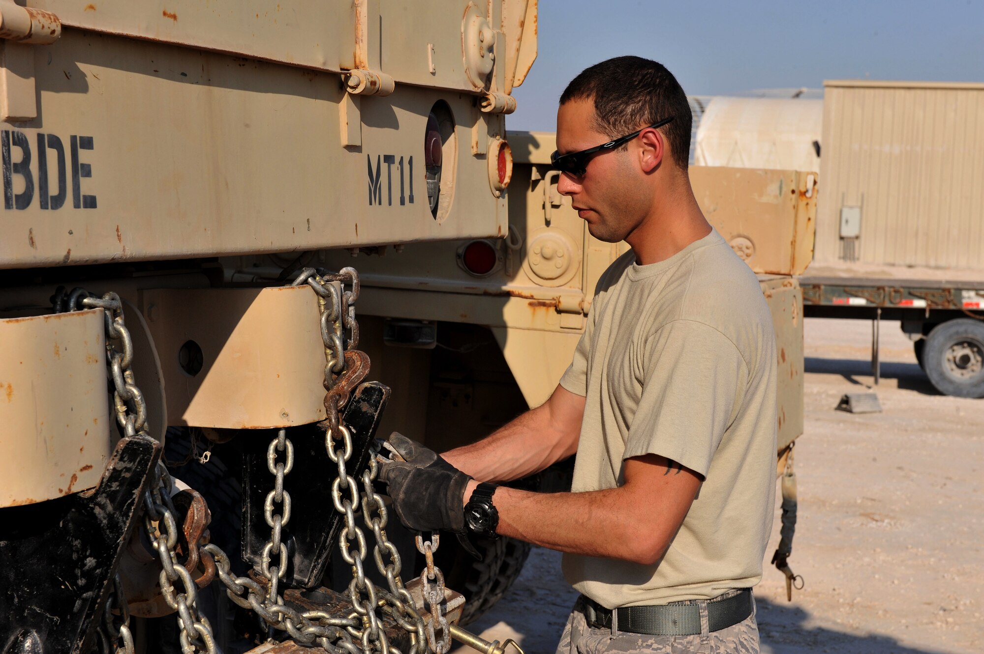 Senior Airman Richard Narvaez secures a U.S. Army M939 5-Ton vehicle to a tow truck at Al Udeid Air Base, Qatar, Jan. 17, 2014. The 379th Expeditionary Logistics Readiness Squadron was tasked to move 51 vehicles and miscellaneous pieces of equipment from the former 11th Air Defense Artillery Brigade, 1st Battalion, 43rd Air Defense Artillery Regiment site, to a collection point for further distribution. All vehicles were inoperable and had to be towed or loaded onto a flatbed trailer for movement. This was the final push in the complete movement of the 1-43rd ADA from their old site to their new location. The move took three days to complete. Narvaez is a 379th ELRS vehicle operator deployed from Minot Air Force Base,N.D., and a Bronx, N.Y., native. (U.S. Air Force photo by Master Sgt. David Miller)