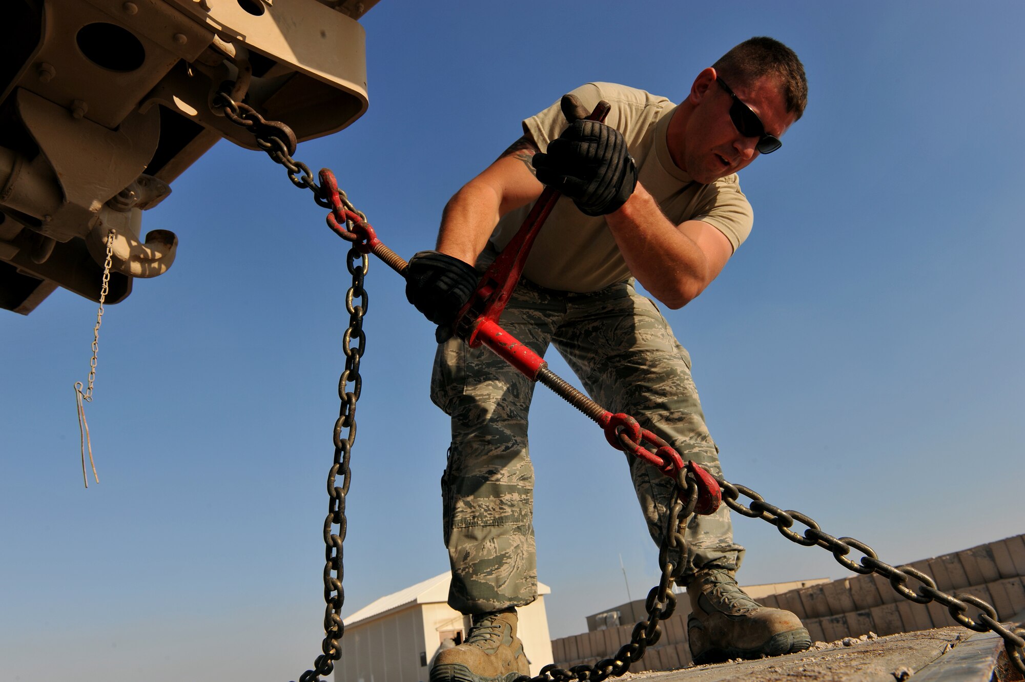 Senior Airman Shane Zimmerman secures a U.S. Army M939 5-Ton vehicle at Al Udeid Air Base, Qatar, Jan. 17, 2014. The 379th Expeditionary Logistics Readiness Squadron was tasked to move 51 vehicles and miscellaneous pieces of equipment from the former 11th Air Defense Artillery Brigade, 1st Battalion, 43rd Air Defense Artillery Regiment site, to a collection point for further distribution. All vehicles were inoperable and had to be towed or loaded onto a flatbed trailer for movement. This was the final push in the complete movement of the 1-43rd ADA from their old site to their new location. The move took three days to complete. Zimmerman is a 379th ELRS vehicle operator deployed from Eglin Air Force Base, Fla., and a Bear Creek, N.C., native. (U.S. Air Force photo by Master Sgt. David Miller)