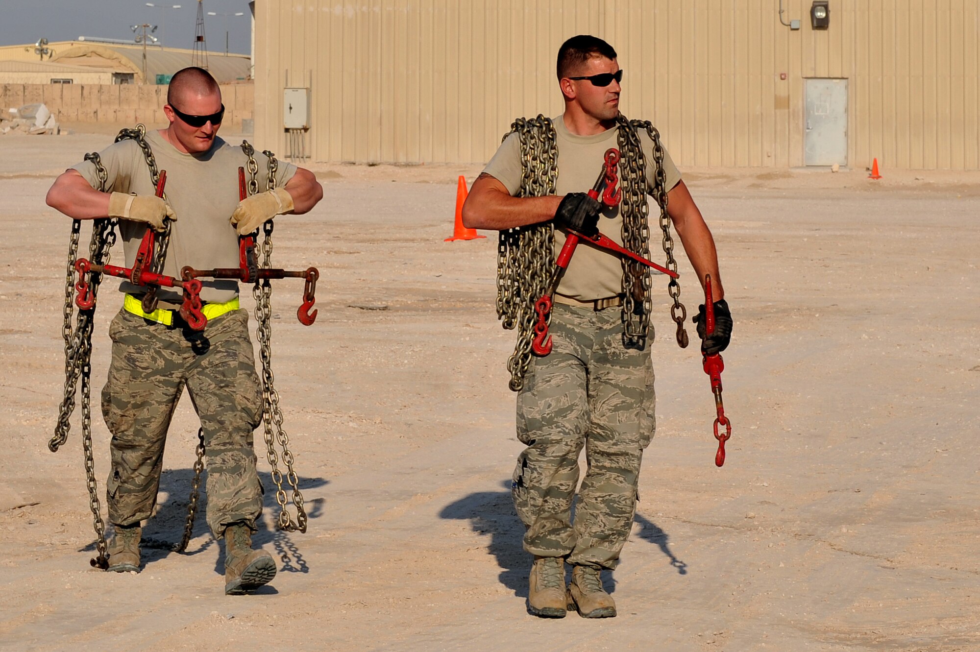 Senior Airman Hunter Spears and Senior Airman Shane Zimmerman prepare to secure a U.S. Army M939 5-Ton vehicle at Al Udeid Air Base, Qatar, Jan. 17, 2014. The 379th Expeditionary Logistics Readiness Squadron was tasked to move 51 vehicles and miscellaneous pieces of equipment from the former 11th Air Defense Artillery Brigade, 1st Battalion, 43rd Air Defense Artillery Regiment site, to a collection point for further distribution. All vehicles were inoperable and had to be towed or loaded onto a flatbed trailer for movement. This was the final push in the complete movement of the 1-43rd ADA from their old site to their new location. The move took three days to complete. Spears is a 379th ELRS vehicle operator deployed from Minot Air Force Base, N.D., and a Fort Smith, Ark., native.  Zimmerman is a 379th ELRS vehicle operator deployed from Eglin Air Force Base, Fla., and a Bear Creek, N.C., native. (U.S. Air Force photo by Master Sgt. David Miller)