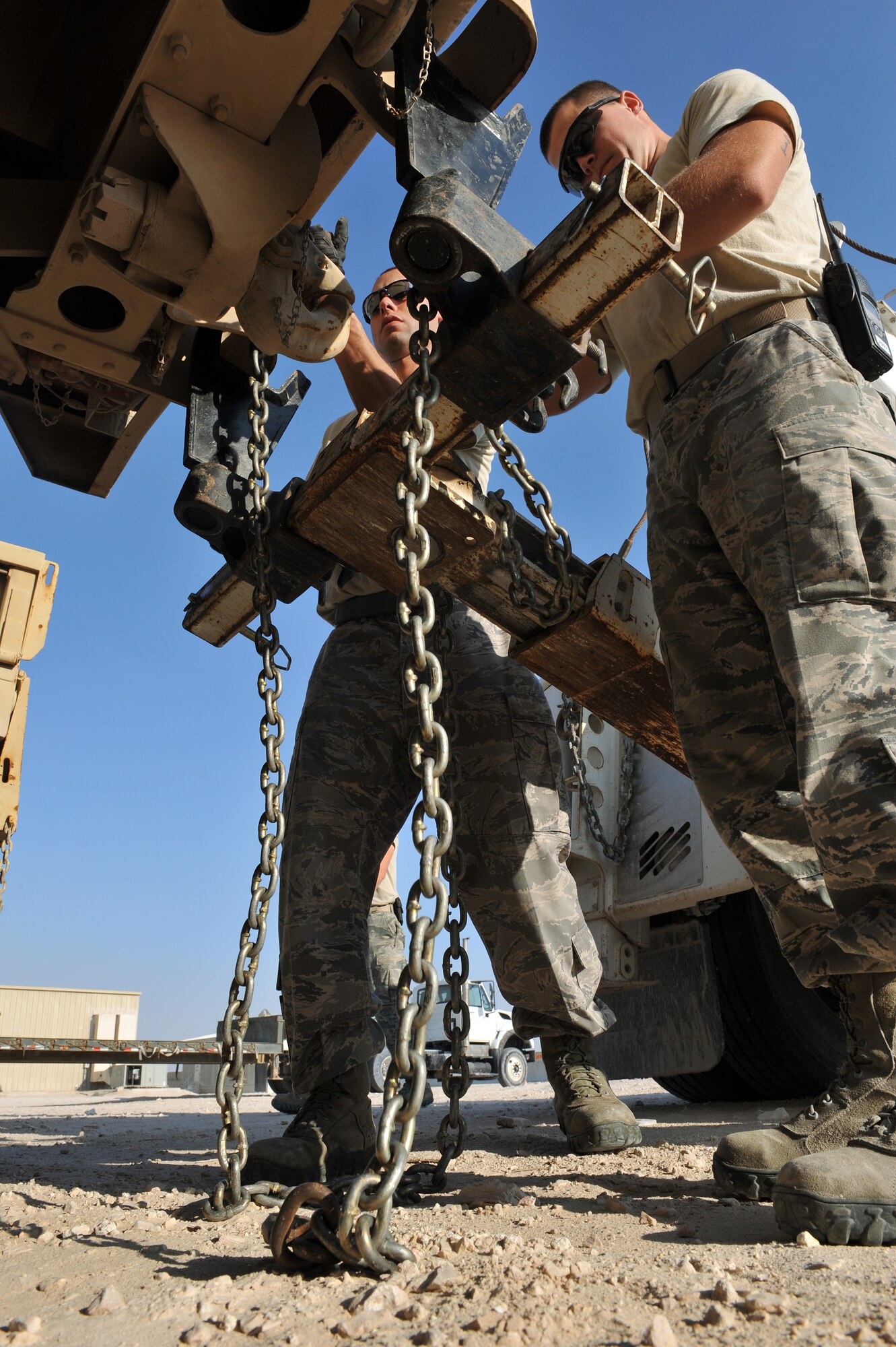 Senior Airman Richard Narvaez (right) and Senior Airman Elisha Bryant hook up a U.S. Army M939 5-Ton vehicle to a tow truck for movement to a collection point at Al Udeid Air Base, Qatar, Jan. 17, 2014.  The 379th Expeditionary Logistics Readiness Squadron was tasked to move 51 vehicles and miscellaneous pieces of equipment from the former 11th Air Defense Artillery Brigade, 1st Battalion, 43rd Air Defense Artillery Regiment site, to a collection point for further distribution. All vehicles were inoperable and had to be towed or loaded onto a flatbed trailer for movement. This was the final push in the complete movement of the 1-43rd ADA from their old site to their new location. The move took three days to complete. Bryant is a 379th ELRS vehicle operator deployed from Seymour Johnson Air Force Base and is a Goldsboro, N.C., native. Narvaez is a 379th ELRS vehicle operator deployed from Minot Air Force Base, N.D., and a Bronx, N.Y., native. (U.S. Air Force photo by Master Sgt. David Miller)
