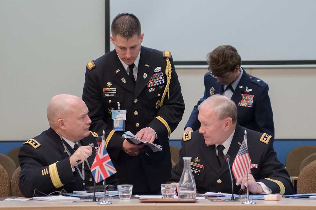 U.S. Army Gen. Martin E. Dempsey, seated right, chairman of the Joint Chiefs of Staff, speaks with U.S. Army Lt. Gen. David R. Hogg, seated left, U.S. military representative to the NATO Military Committee, while attending the 170th NATO Chiefs of Defense meeting at NATO headquarters in Brussels, Jan. 22, 2014.