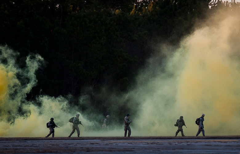 Airmen from the 1st, 2nd and 3rd Combat Camera Squadron use smoke for cover as they cross through a field during the tactical portion of the Ability to Survive and Operate exercise Jan. 14, 2014, at North Auxiliary Air Field, S.C. The 1st Combat Camera Squadron located at Joint Base Charleston, S.C., hosted the exercise from Jan. 6 through 17. (U.S. Air Force photo/Senior Airman Dennis Sloan)