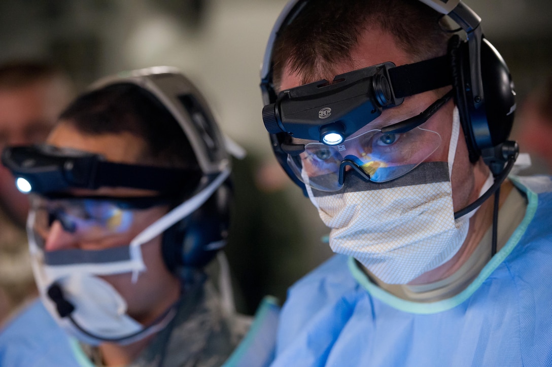 Lt. Col. Gerald Fortuna (right) performs a simulated exploratory laparotomy surgery while in flight aboard a C-17 Globemaster III during a field exercise Jan. 17, 2014, at the Joint Readiness Training Center, Fort Polk, La. Service members at JRTC 14-03 are educated in combat patient care and aeromedical evacuation in a simulated combat environment. Fortuna is a trauma surgeon with the 86th Medical Group at Ramstein Air Base, Germany. (U.S. Air Force photo/Tech. Sgt. Matthew Smith)