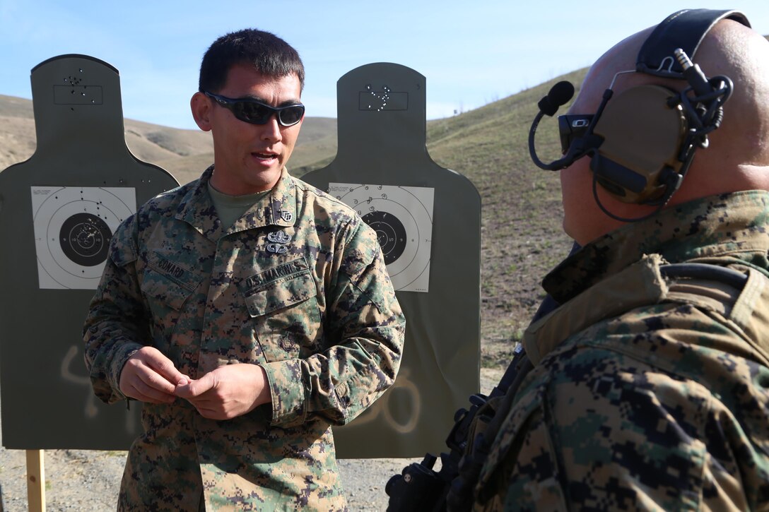 Staff Sgt. Raymond Conard, a Special Operations Maritime Raid Force Security Element Course instructor, gives Staff Sgt. Jon Calaway, an explosive ordnance disposal technician with Combat Logistics Battalion 11, now part of the 11th Marine Expeditionary Unit, proper adjustments that he should make to improve his accuracy during a live-fire exercise here Jan. 23. Personnel approached their targets after each drill was completed in order to observe their shot groups. Instructors would give proper adjustments if needed.