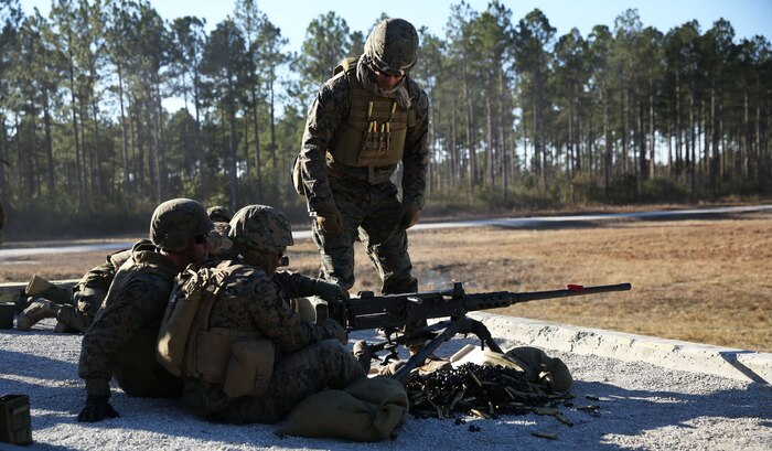 An instructor with the Battle Skills Training School aboard Camp Lejeune, N.C. provides guidance on a M2 Browning .50-caliber machine gun to a Marine with 2nd Marine Logistics Group during a live-fire exercise portion of the BSTS machine gunner course Jan. 24, 2014. Marines attending the course had to become proficient with a multitude of weapons within a two week period. (U.S. Marine Corps photo by Lance Cpl. Shawn Valosin)