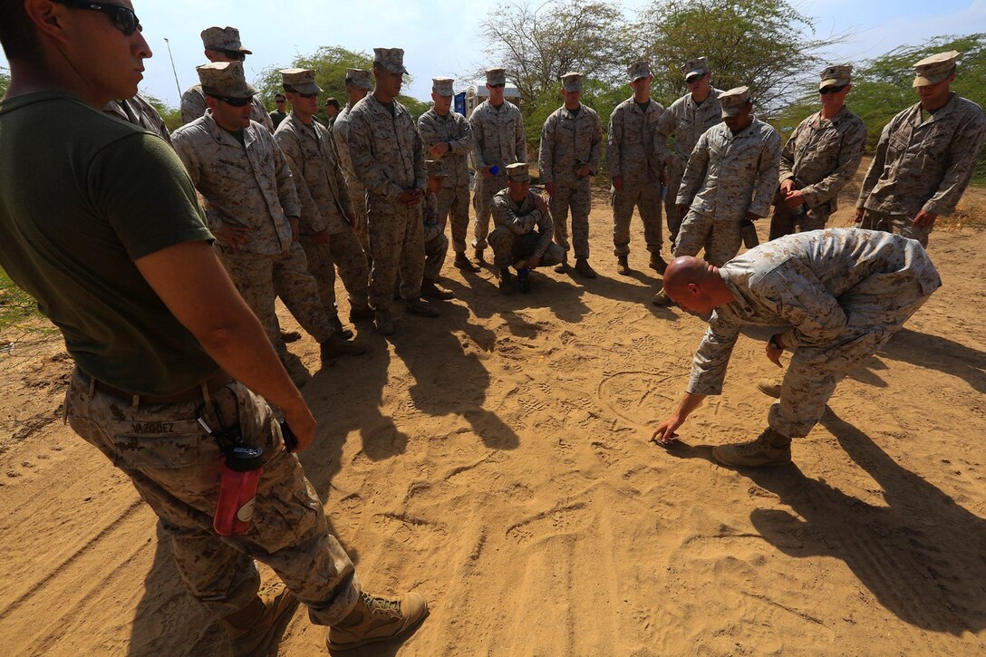 CAMP LEMONNIER, DJIBOUTI (Jan. 10, 2014)  – U.S. Marine Corps Gunnery Sgt. Patrick Hilty, staff noncommissioned officer-in-charge of Explosive Ordnance Disposal Detachment, 13th Marine Expeditionary Unit, draws out a diagram in the sand to better demonstrate measures to counter improvised explosive devices (IED) during training at Camp Lemonnier, Djibouti Jan. 10, 2014. Approximately 50 Marines assigned to Charlie Company, 13th MEU completed counter IED training, which covered a wide variety of techniques to defeat enemy IEDs. The 13th MEU is deployed with the Boxer Amphibious Ready Group as a theater reserve and crisis response force throughout the U.S. 5th Fleet area of responsibility.  (U.S. Marine Corps photo by Staff Sgt. Matt Orr/Released)