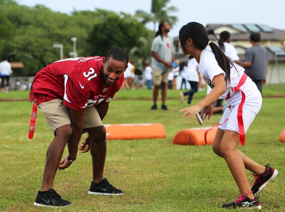 Justin Bethel, cornerback for the Arizona Cardinals, tries to grab a flag from a Mokapu student during the NFL Play 60 event, Jan. 22, 2014. (U.S. Marine Corps photo by Lance Cpl. Suzanna Knotts)