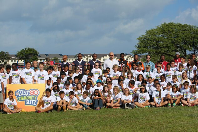 National Football League players pose with Mokapu Elementary School students on campus during the NFL Play 60 initiative, Jan. 22, 2014. The Play 60 program is the NFL’s national youth health and fitness movement. Players from the Arizona Cardinals, Chicago Bears, Cincinnati Bengals and Jacksonville Jaguars played with the 5th and 6th graders of Mokapu while players from the Minnesota Vikings, Baltimore Ravens and Cleveland Browns painted a mural for the Semper Fit Center Gym. (U.S. Marine Corps photo by Lance Cpl. Suzanna Knotts)