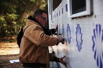 Marines with Alpha Company, 8th Engineer Support Battalion, 2nd Marine Logistics Group work in unison to attach a layer of insulation to a Cape Carteret, N.C. home as part of a volunteer project with Habitat for Humanity International, Jan. 23, 2014. The Marines used this opportunity to expand on their skills as combat engineers and to give back to the community. (U.S. Marine Corps photo by Lance Cpl. Shawn Valosin)