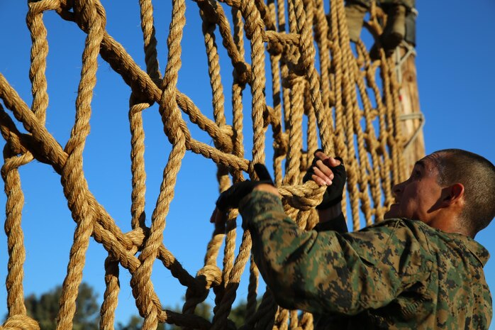 Co I recruit Marquez Alberto climbs up a rope wall during his run throught the depot's Confidence Course. Recruits ran through the course two times during the First Phase of training and again during the Crucible.