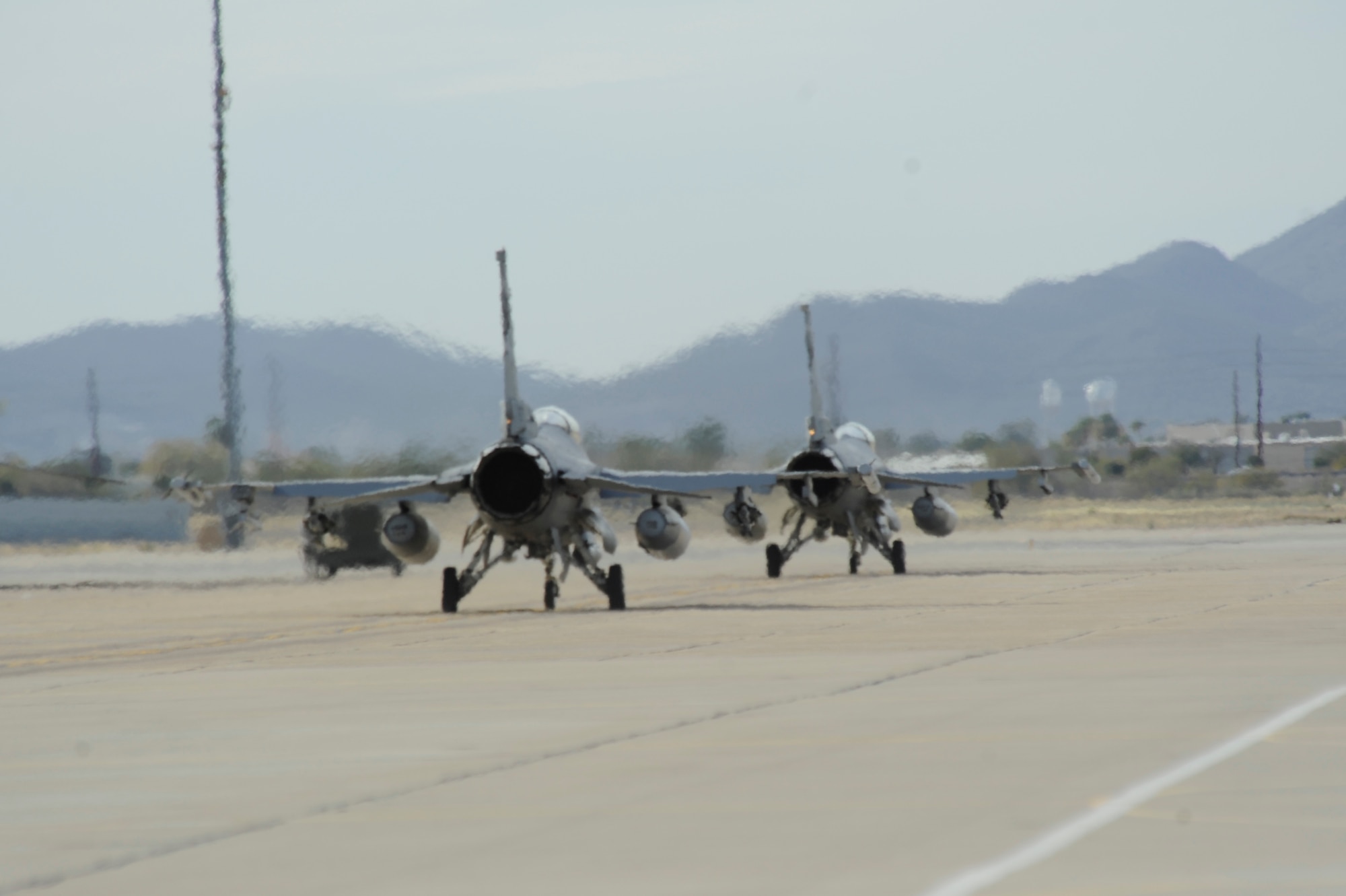 Two F-16 Fighter Falcons prepare to take off from Davis-Monthan Air Force Base, Ariz., Jan. 23, 2013. Ten jets and 150 South Dakota Air National Guardsmen traveled to D-M to take part in Operation Snowbird, where they will have the chance to conduct mandatory training. (U.S. Air Force photo by Airman 1st Class Betty R. Chevalier/released)