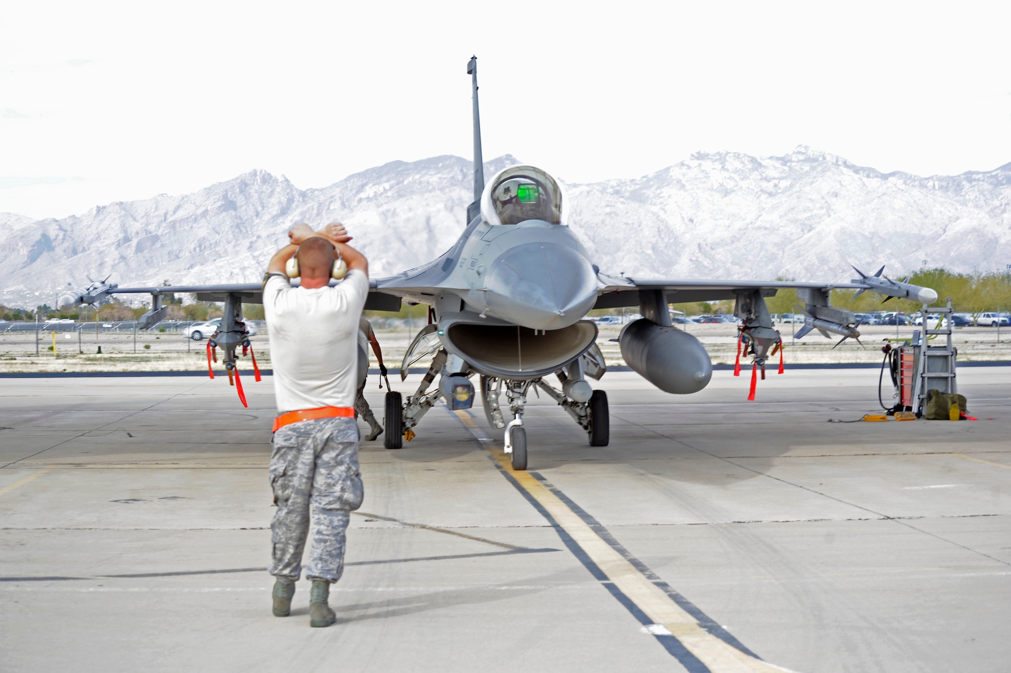 U. S Air Force Master Sgt. Shawn Emerson, 114th Aircraft Maintenance Squadron crew chief, signals to an F-16 Fighter Falcon pilot to hold at Davis-Monthan Air Force Base, Ariz, Jan. 23, 2013. The F-16s, stationed out of Joe Foss Field in Sioux Falls, S.D., conducted mandatory readiness training which gave pilots a chance to use different military ranges then what is available in South Dakota. (U.S. Air Force photo by Airman 1st Class Betty R. Chevalier/released)