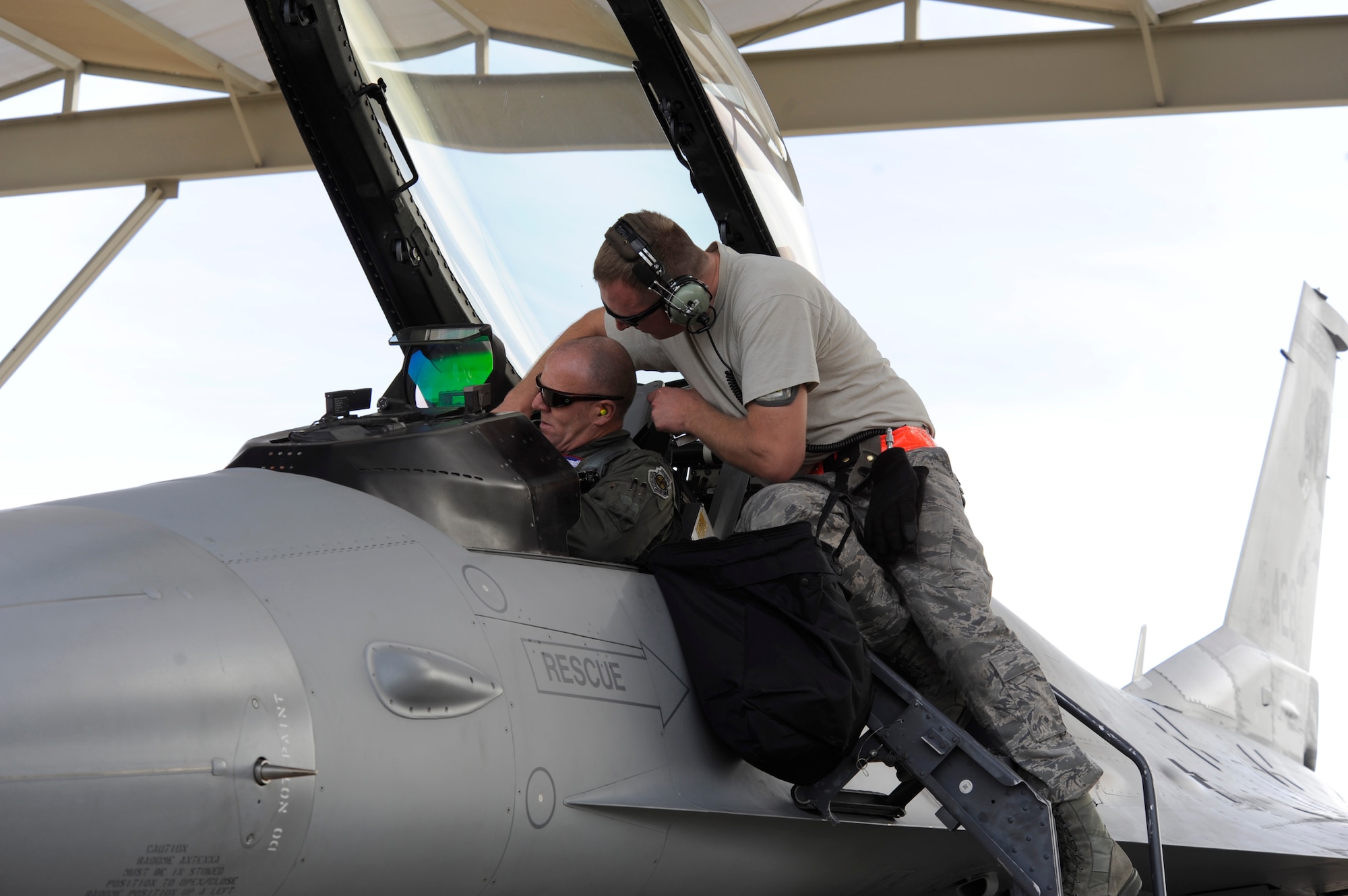 U. S Air Force Master Sgt. Chris Thesenvitz, 114th Aircraft Maintenance Squadron crew chief, assists Lt. Col. Todd Sheridan, 114th Fighter Wing pilot, with his harness while getting ready for take-off at Davis-Monthan Air Force Base, Ariz., Jan. 23, 2013. The South Dakota Air National Guard was at D-M for Operation Snowbird, which gives northern ANG units a chance to conduct mandatory training in the optimal weather while using Southern Arizona’s military ranges. (U.S. Air Force photo by Airman 1st Class Betty R. Chevalier/released)