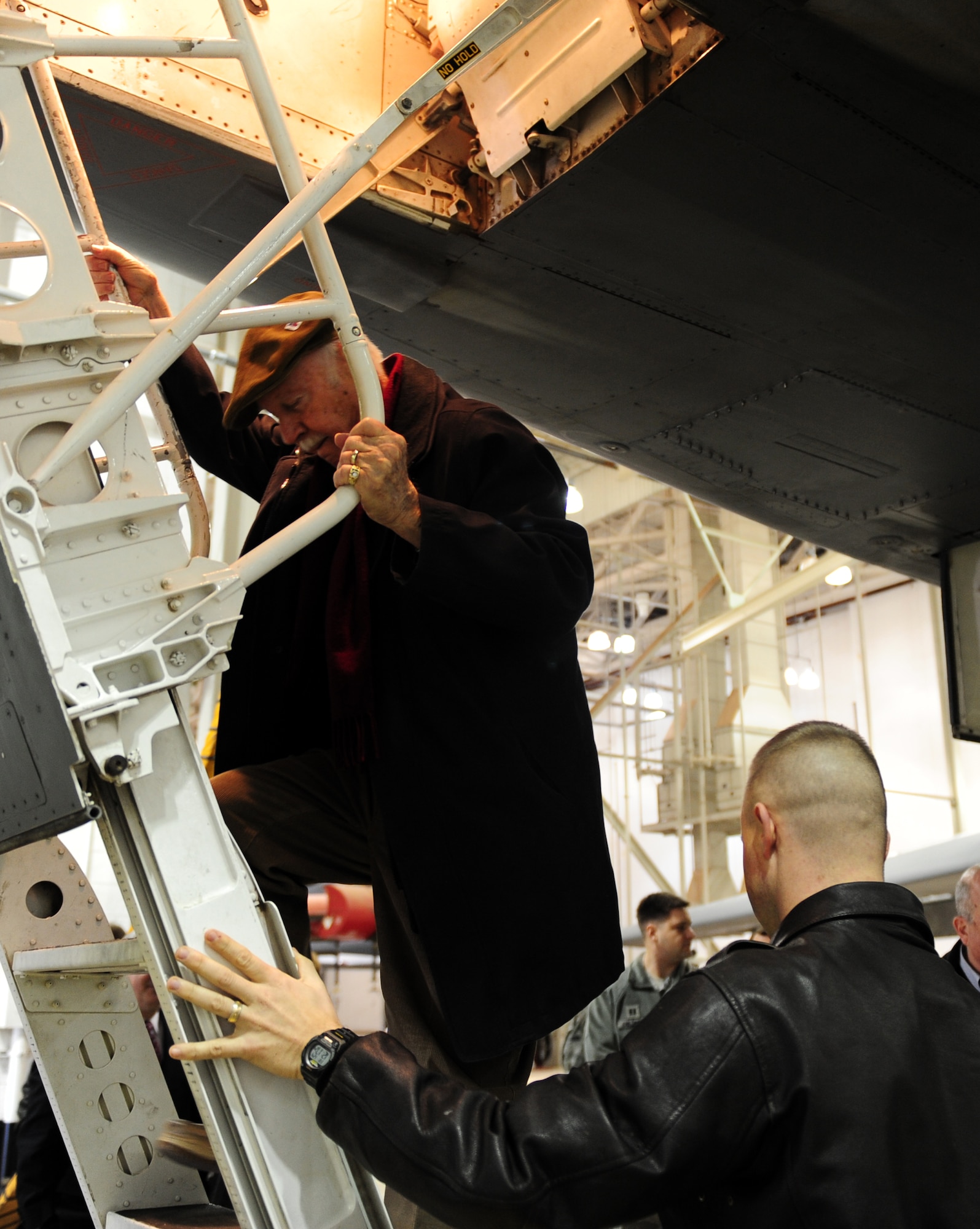 Bob Christopher, 7th Bomb Wing vice commander honorary commander, left, is helped up a B-1B Lancer’s ladder during the B-1 Integrated Battle Station Ceremony Jan. 24, 2014 at Dyess Air Force Base, Texas. These new upgrades will allow the aircraft to work better with other joint and coalition forces. Dyess is the first base to receive the first operational IBS upgraded B-1, but the program is scheduled to upgrade other B-1s through 2019. (U.S. Air Force photo by Senior Airman Kia Atkins/Released)