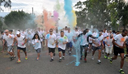 Members of Joint Task Force-Bravo cross the starting line of the first "Color Me Run" 5K at Soto Cano Air Base, Honduras, Jan. 24, 2014. Participants who ran the course were bombarded with colored powder throughout the course. The run promoted morale as well as fitness, and was sponsored by the Army Support Activity's office of Family, Morale, Welfare and Recreation.  (U.S. Air Force photo by Capt. Zach Anderson)