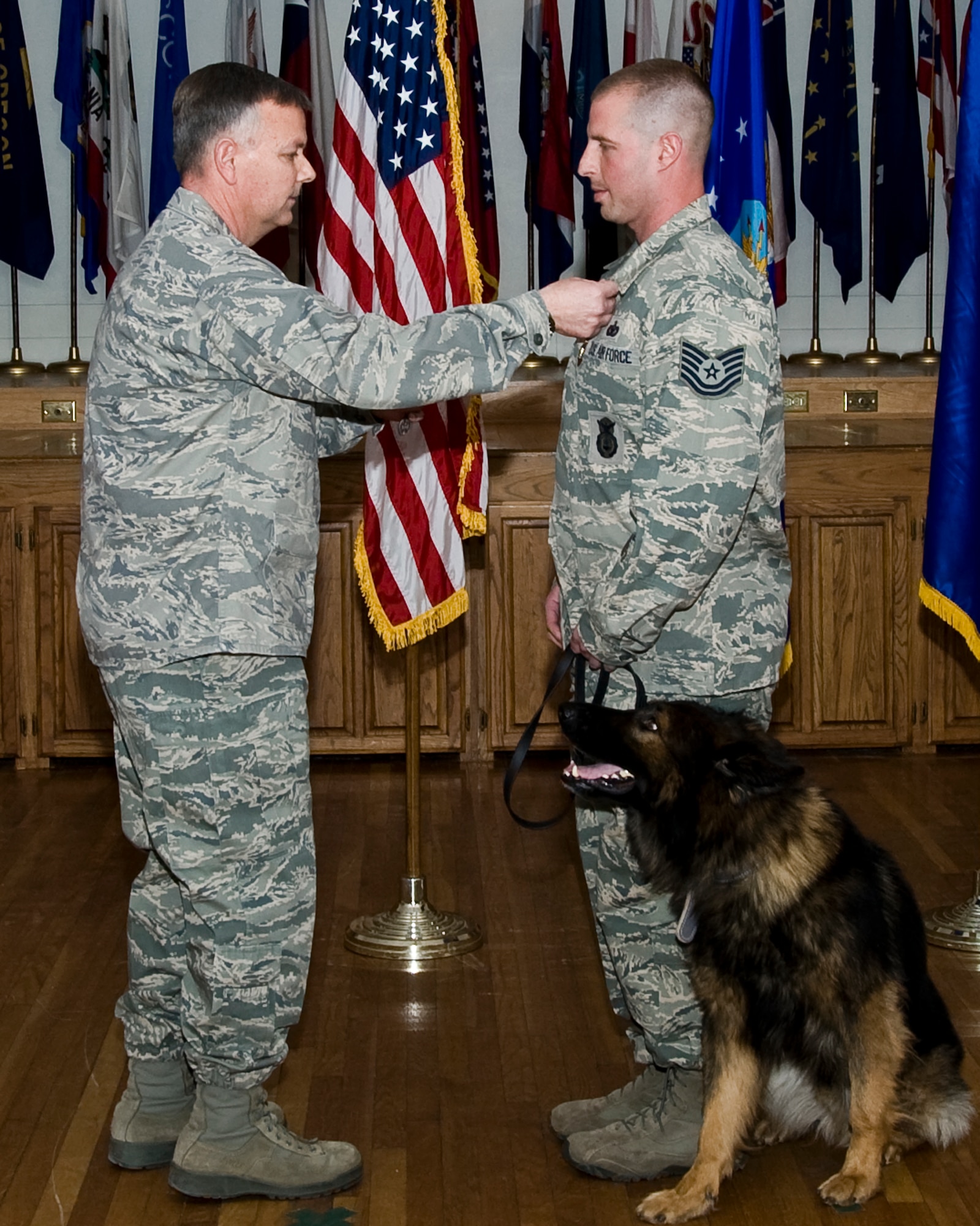 U.S. Air Force Brig. Gen. Glen VanHerck, 7th Bomb Wing commander, presents Tech. Sgt. Rafael Rhodes, 7th Security Forces Squadron military working dog trainer, with the Purple Heart and Air Force Combat Action Medals Jan. 24, 2014, at Dyess Air Force Base, Texas. Rhodes was awarded for being wounded in action against an enemy of the United States and for directly engaging an enemy while his life was at risk of grave danger while deployed in Afghanistan. (U.S. Air Force photo by Staff Sgt. Richard Ebensberger/Released)