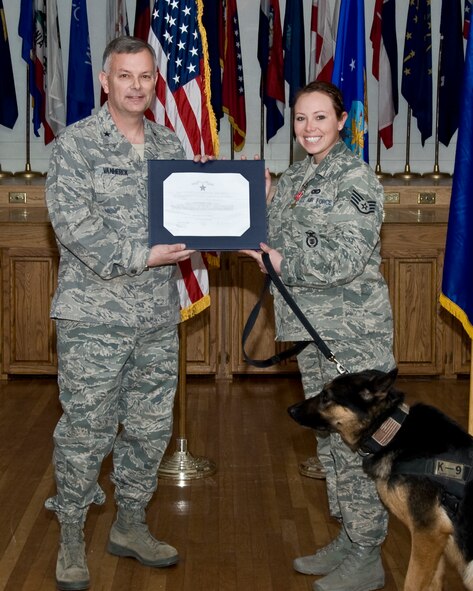 U.S. Air Force Brig. Gen. Glen VanHerck, 7th Bomb Wing commander, presents Staff Sgt. Erica McRell, 7th Security Forces Squadron military working dog trainer, with the Bronze Star Medal Jan. 24, 2014, at Dyess Air Force Base, Texas. McRell took part in the planning and execution of more than 100 combat patrols in southern Afghanistan. Her position in the unit, lead, assumed the most risk with minimal direct protection. (U.S. Air Force photo by Staff Sgt. Richard Ebensberger/Released)