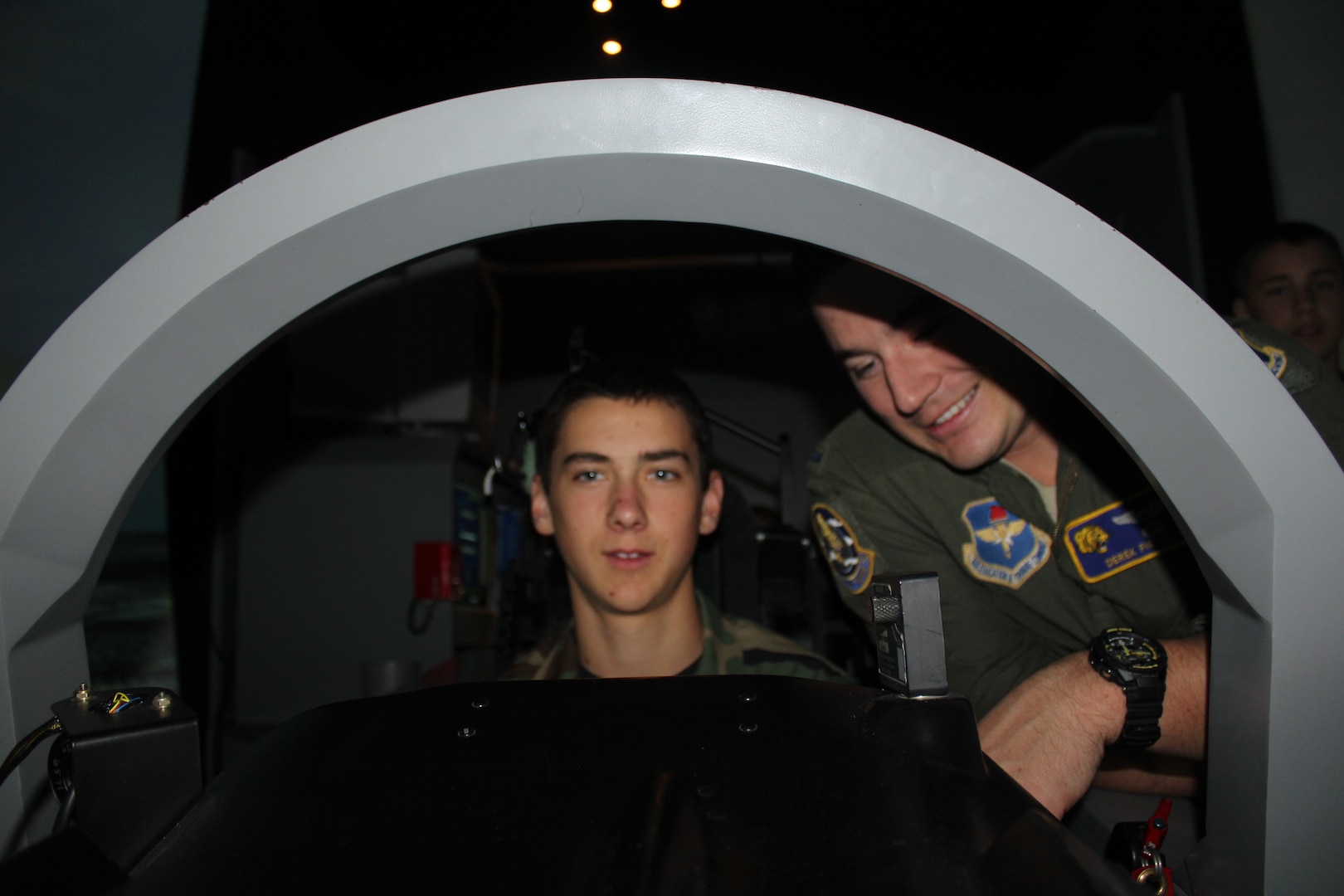 Lt. Derek Fiebig (right), 559th Flying Training Squadron T-6 simulator instructor, teaches Civil Air Patrol Cadet Stephen Spalding how to fly the aircraft on the T-6 simulator on Joint Base San Antonio-Randolph Dec. 11.  (U.S. Air Force photo by Lt. Col. Andreas K. Wesemann) (Released)