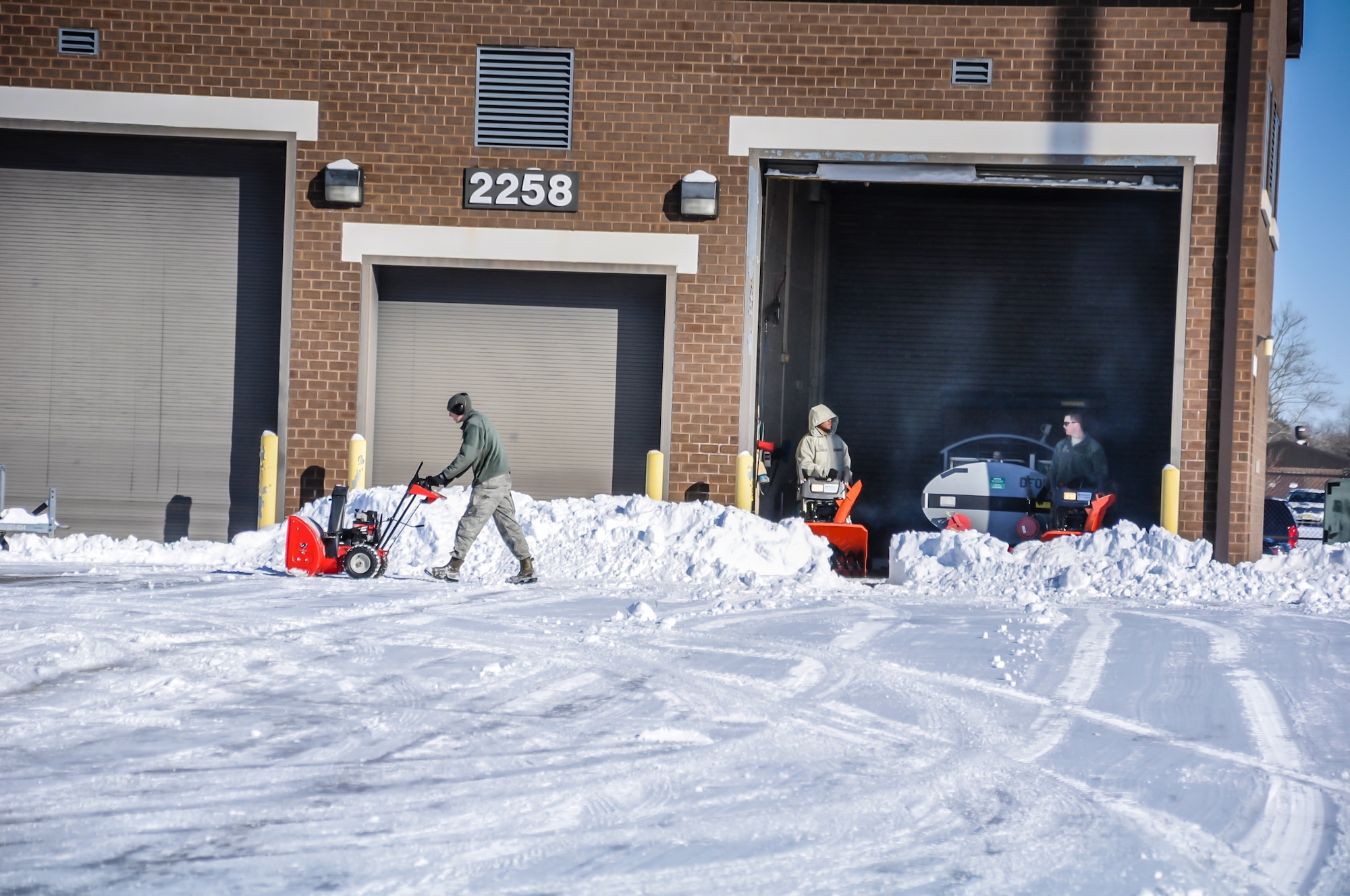 Members of the joint base work hard to clear McGuire Field, streets and parking lots Jan. 22 2014, on Joint Base McGuire-Dix-Lakehurst, N.J.  The joint base was blanketed with over 12 inches of snow from Tuesday’s storm.  (U.S. Air Force photo by Wayne Russell/Released) 
