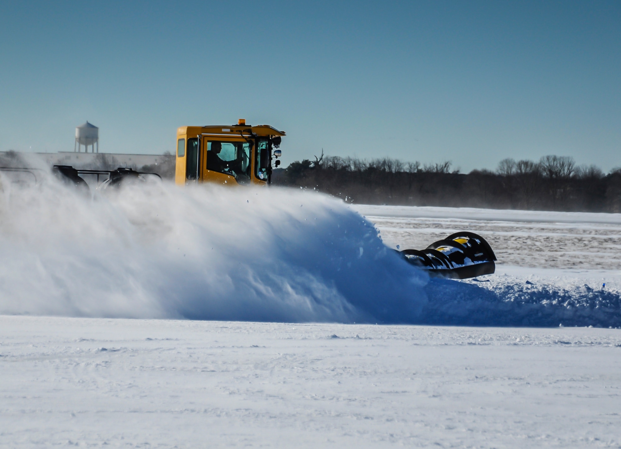 A large snowplow clears snow from McGuire Field, Jan. 22.2014, on Joint Base McGuire-Dix-Lakehurst, N.J.  A variety of heavy equipment is used to clear the flight line and runway in order for the base to return to normal operations and for missions to resume.  (U.S. Air Force photo by Wayne Russell/Released)
