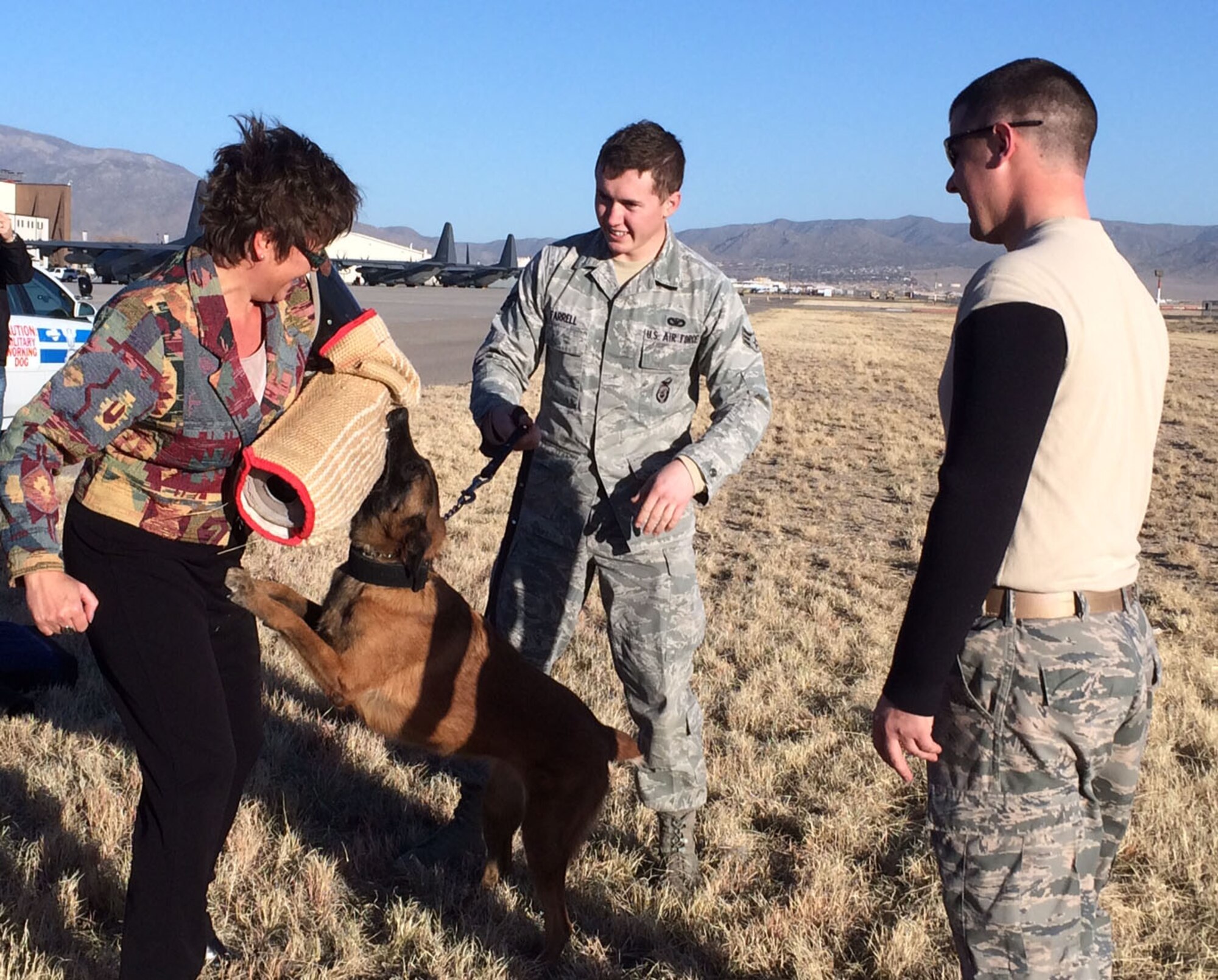 Dr. Vanessa Hawker, associate budget director at the University of New Mexico's Health Science Center, gets ana hands-on demonstration of the 377th Security Forces K-9 unit by dog handlers Airman 1st Class Stephen Farrell and Staff Sgt. William Hollendonner. Senior leaders from the UNM healthcare system received a tour of several facets of the base. (Courtesy photo)  